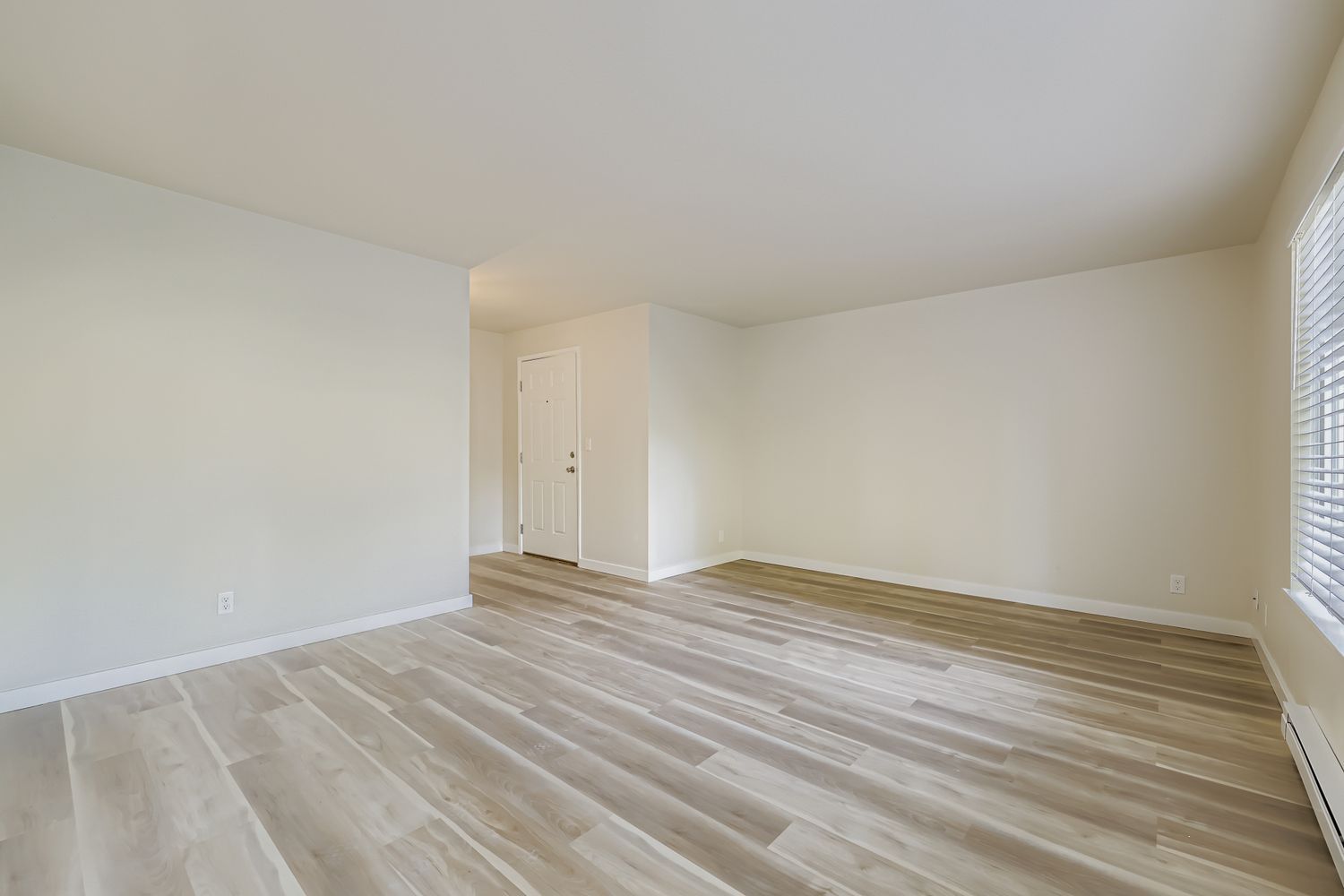Photo of a large open space living room, with the entrance in the background