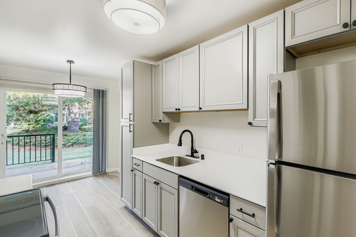 Photo of a kitchen with the dining area in the middleground and the porch in the background