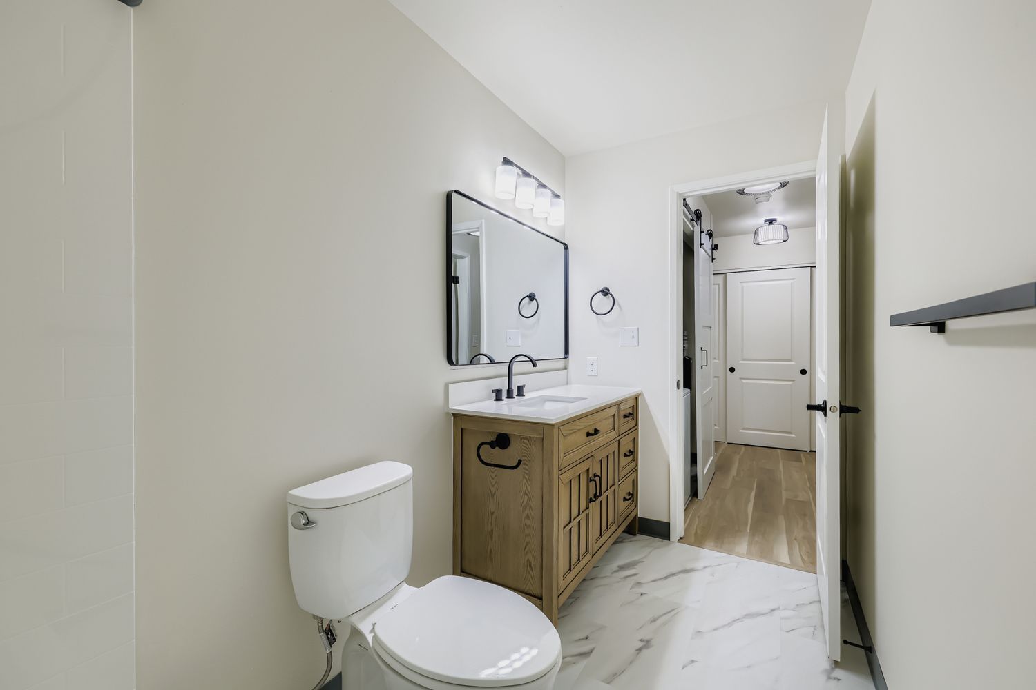 Photo of a long bathroom with a wide vanity mirror and sink