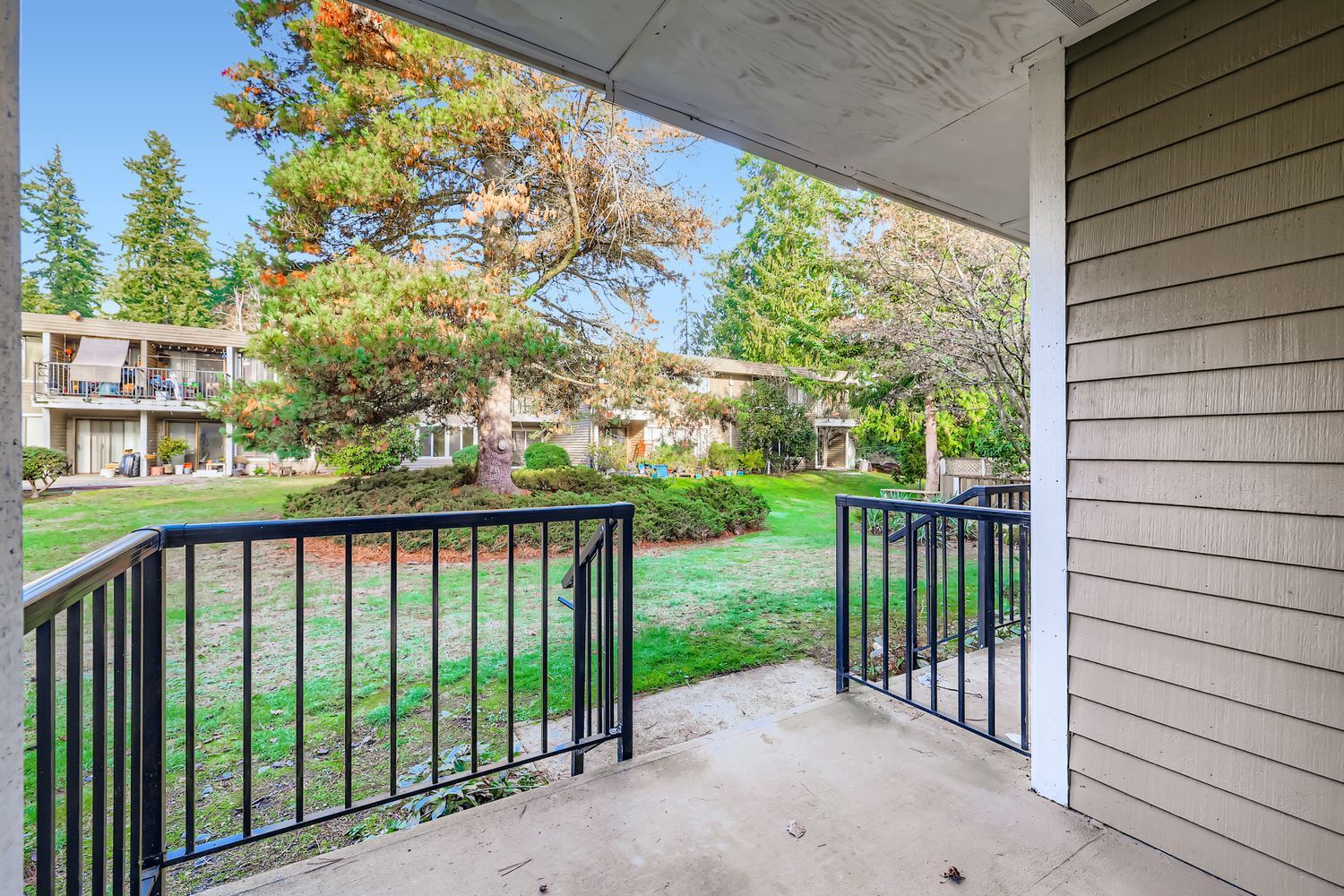 Photo seen from an entrance to a unit, showing the courtyard in the middleground and a building in the background