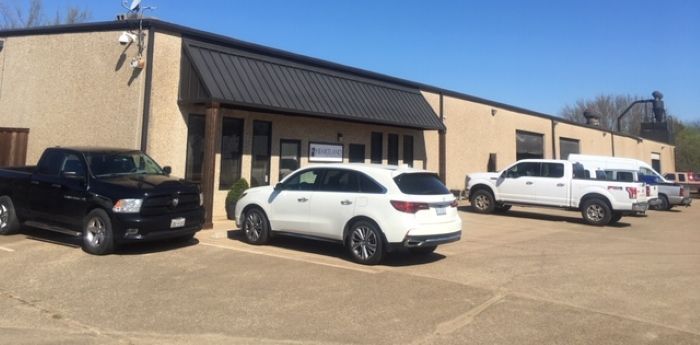 A row of cars are parked in front of a building.
