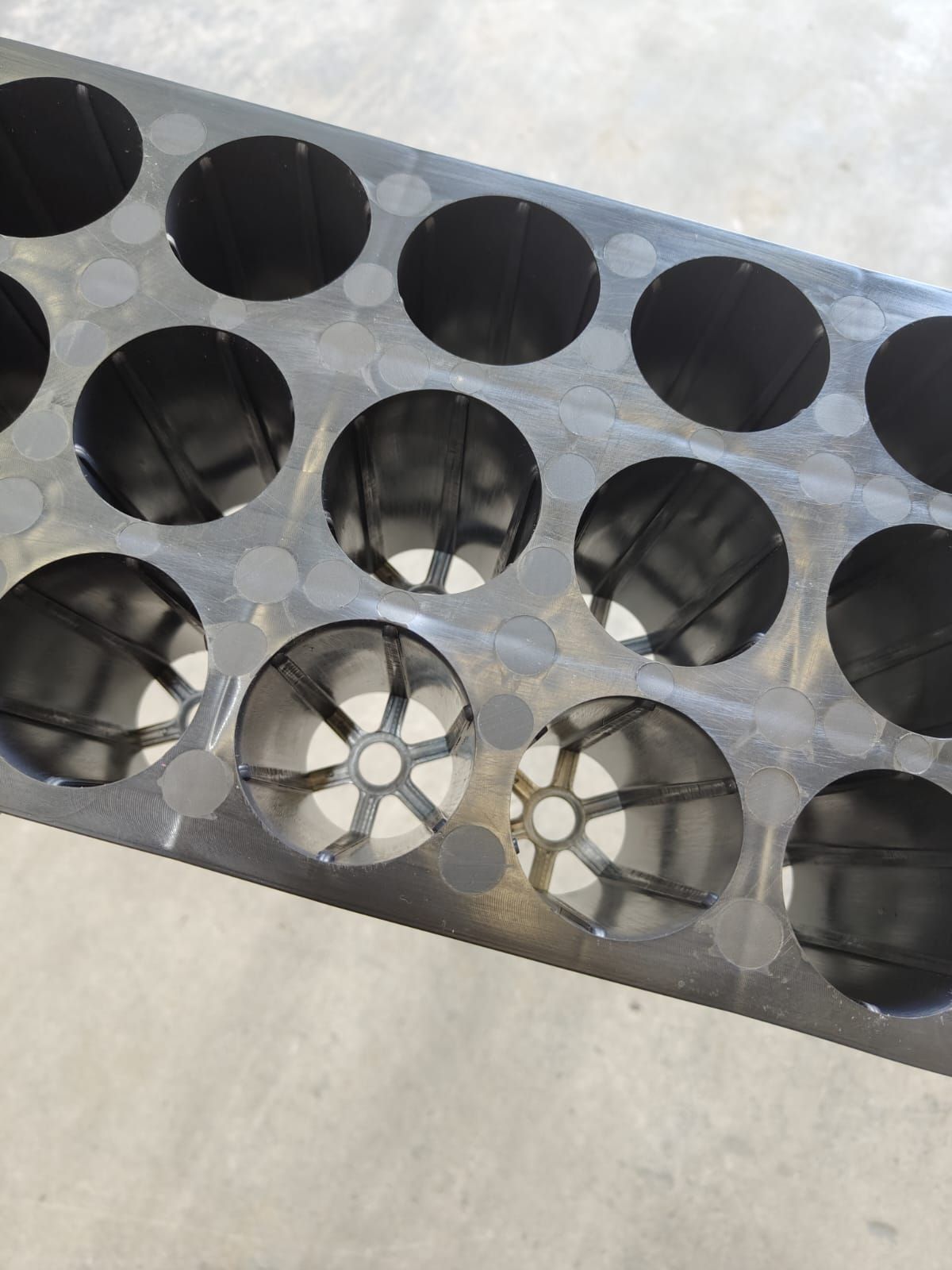 A tray of black plastic cups and a tray of black plastic cups on a white background.