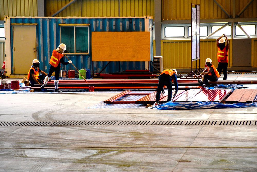 A Group of Construction Workers Are Working on A Building — Watto's Earthmoving & Machinery Hire in Atherton, QLD