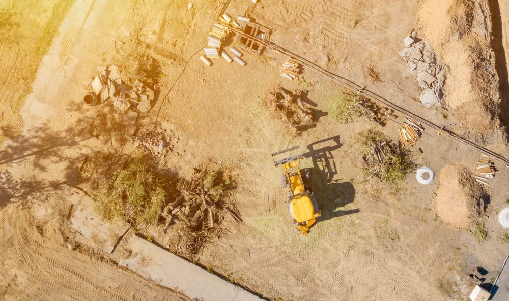 An Aerial View of A Construction Site with A Yellow Bulldozer — Watto's Earthmoving & Machinery Hire in Atherton, QLD