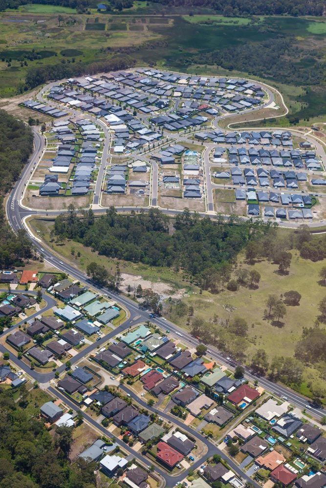 An Aerial View of A Residential Area with Lots of Houses and Trees — Watto's Earthmoving & Machinery Hire in Atherton, QLD