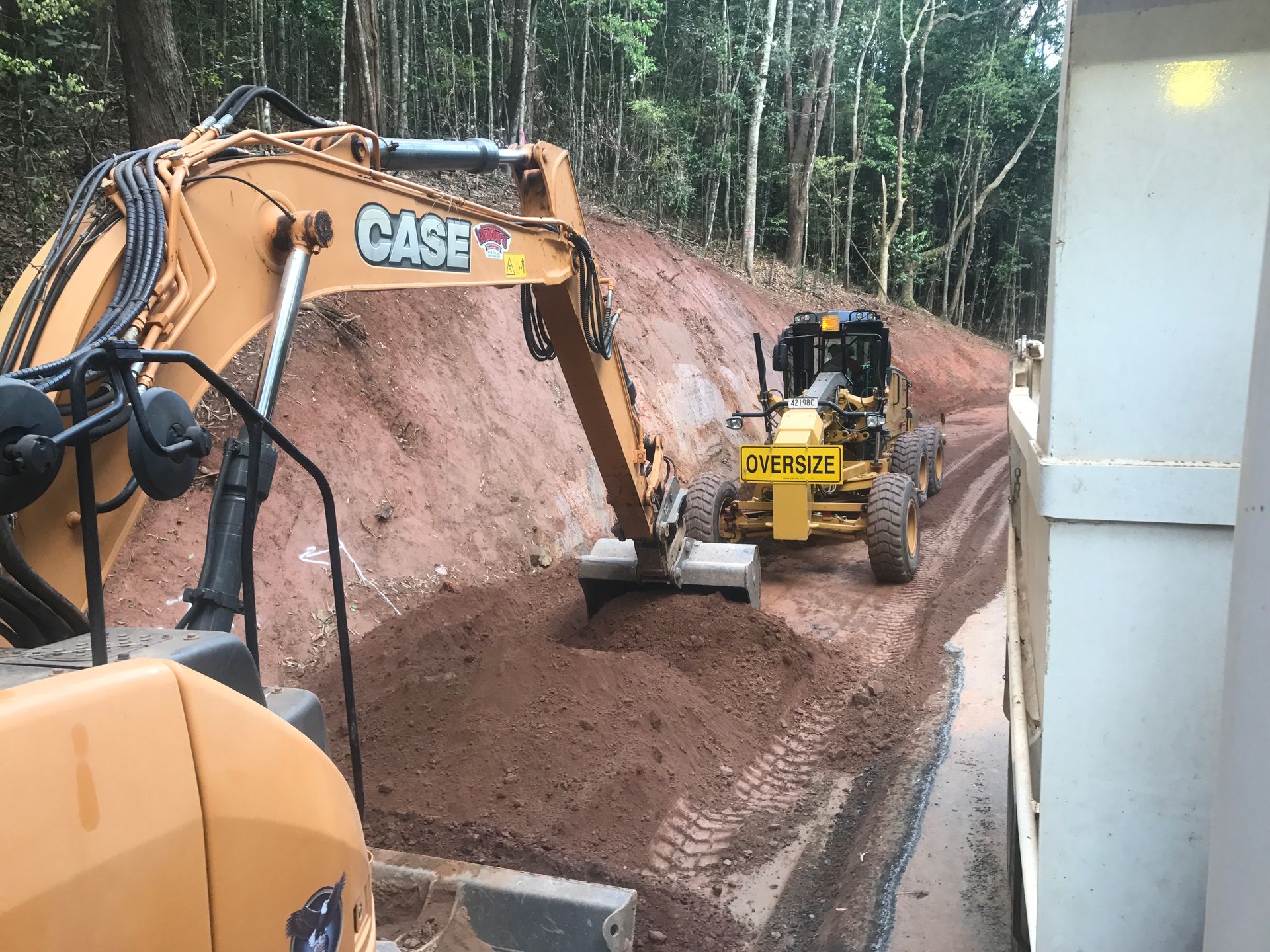 An Aerial View of A Large Lake Surrounded by Trees and A Road — Watto's Earthmoving & Machinery Hire in Atherton, QLD