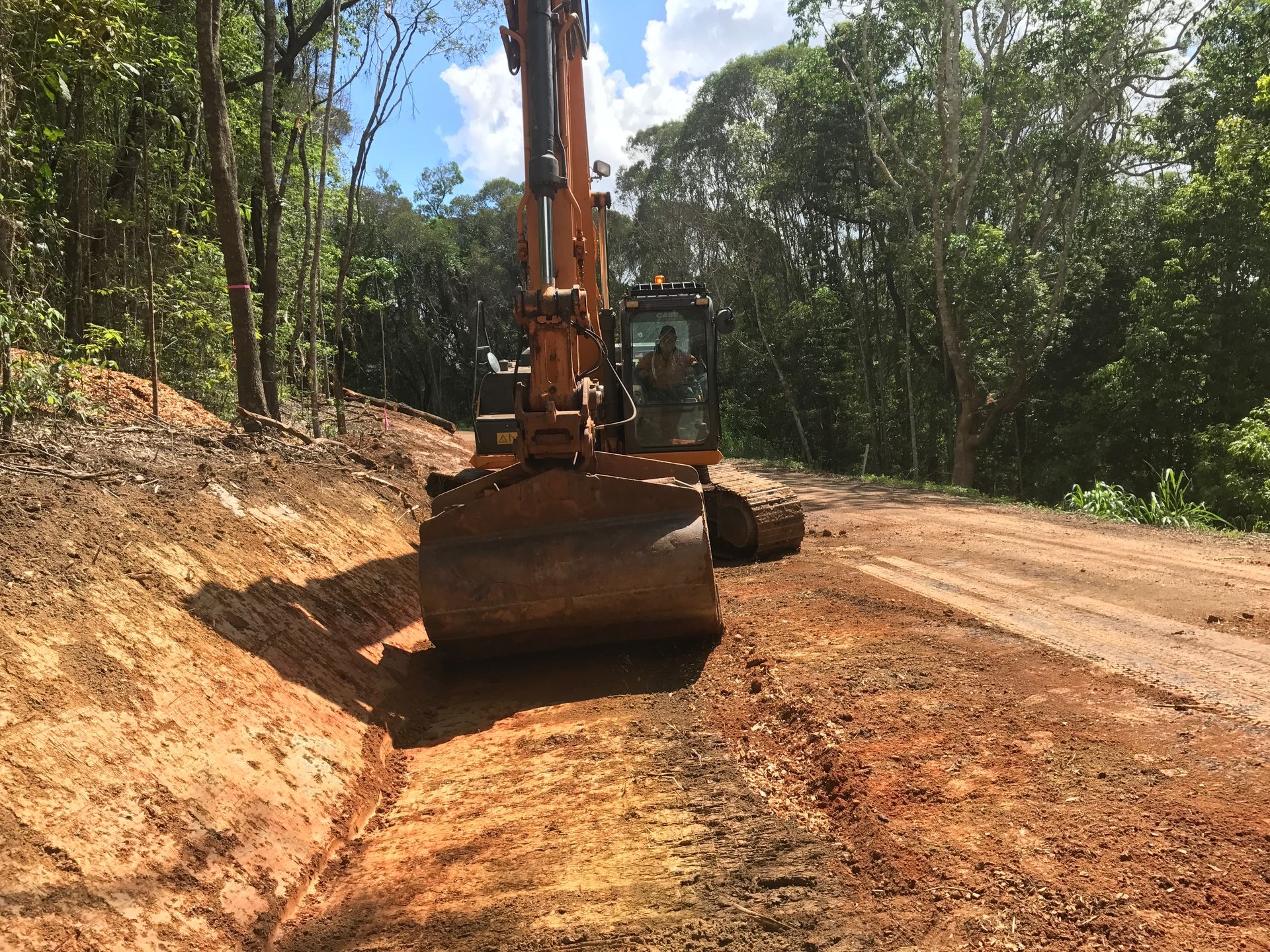 A Large Tree Stump Is Being Removed by An Excavator — Watto's Earthmoving & Machinery Hire in Mareeba, QLD