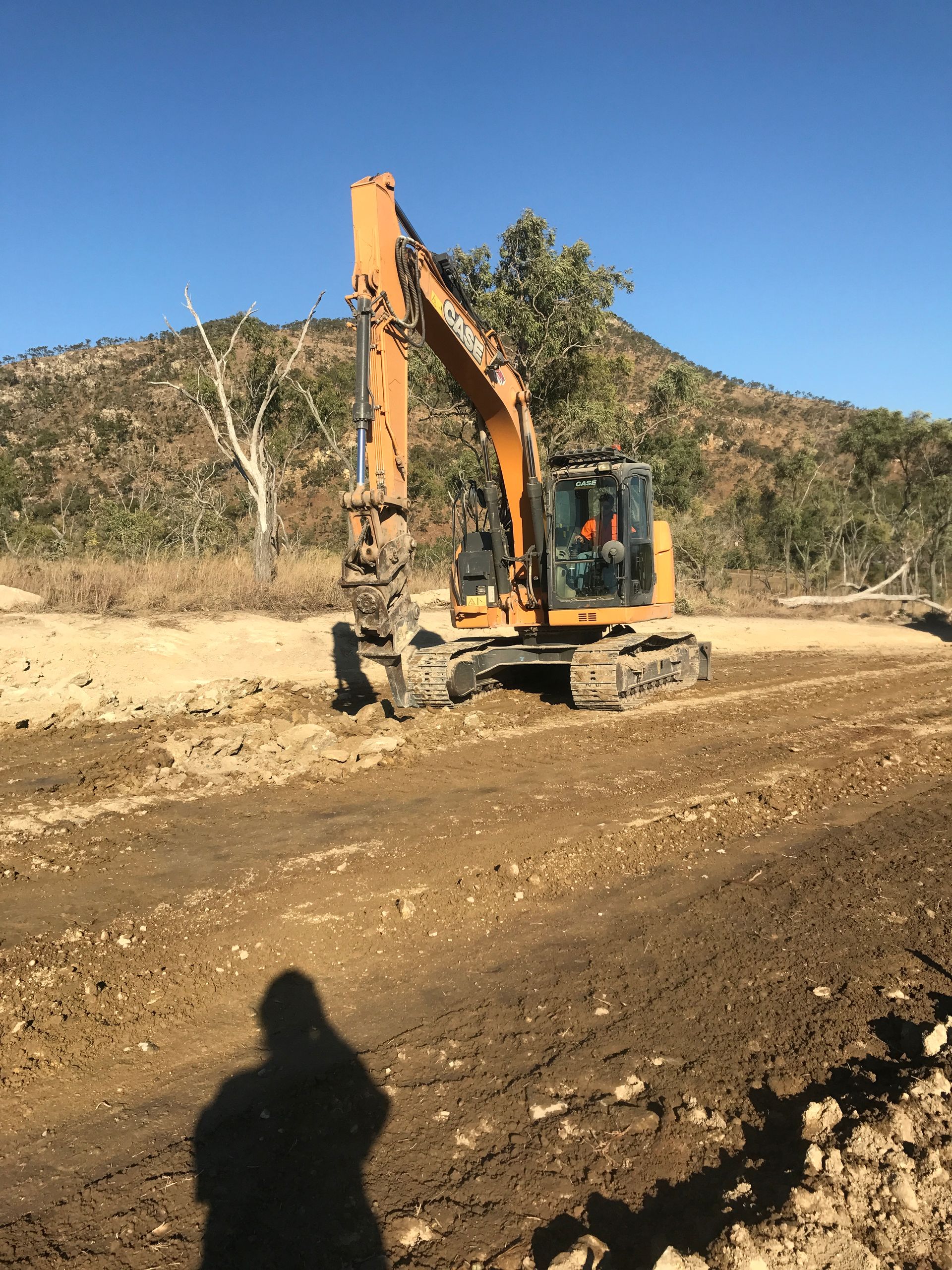 A Bulldozer and An Excavator Are Working on A Construction Site — Watto's Earthmoving & Machinery Hire in Atherton, QLD