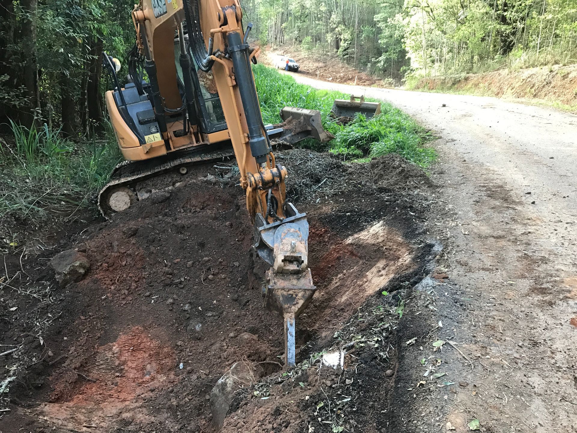 A Group of Construction Workers Are Looking at A Blueprint — Watto's Earthmoving & Machinery Hire in Mareeba, QLD