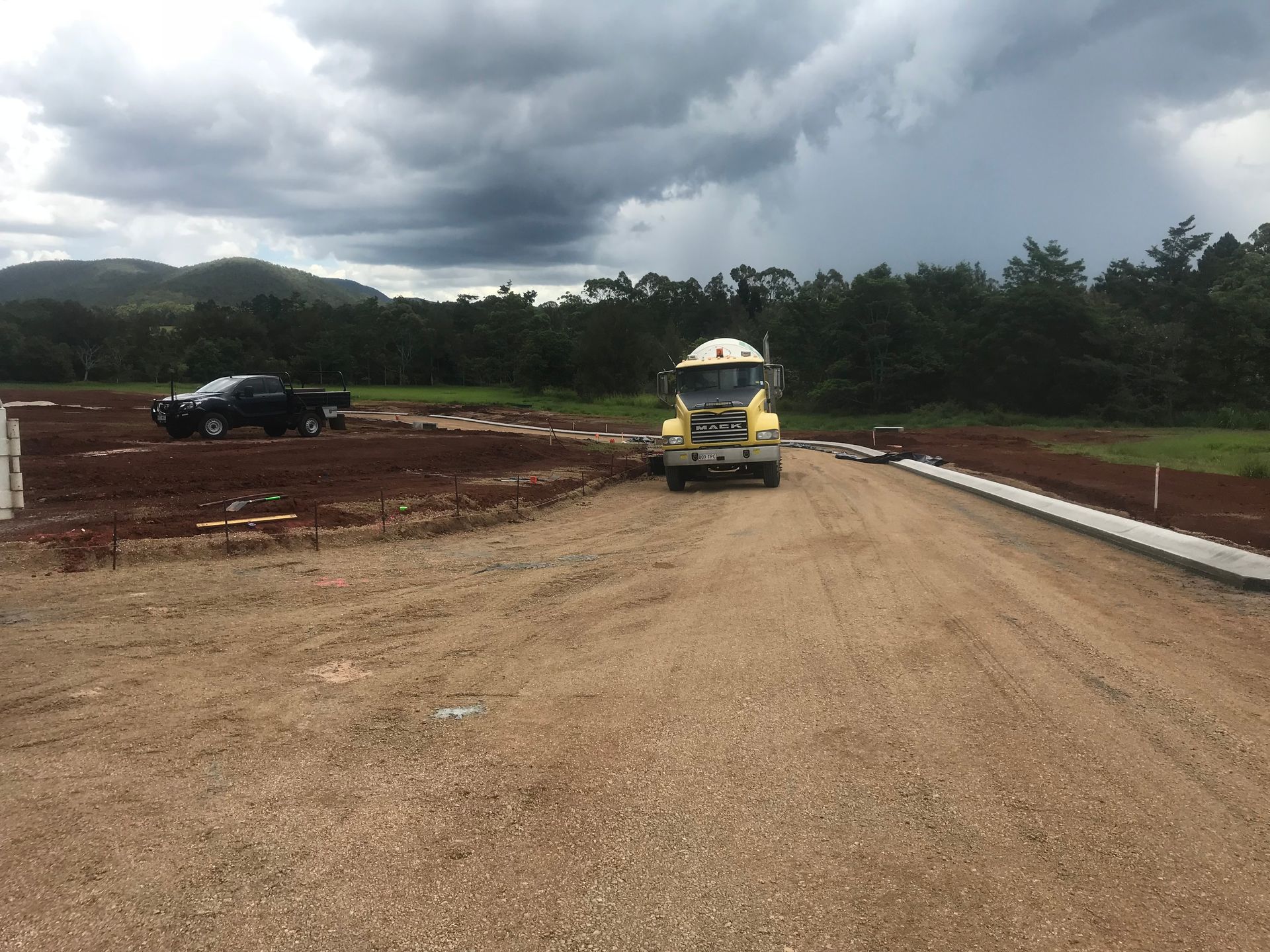 A Driveway Leading to A House with A White Garage Door — Watto's Earthmoving & Machinery Hire in Mareeba, QLD