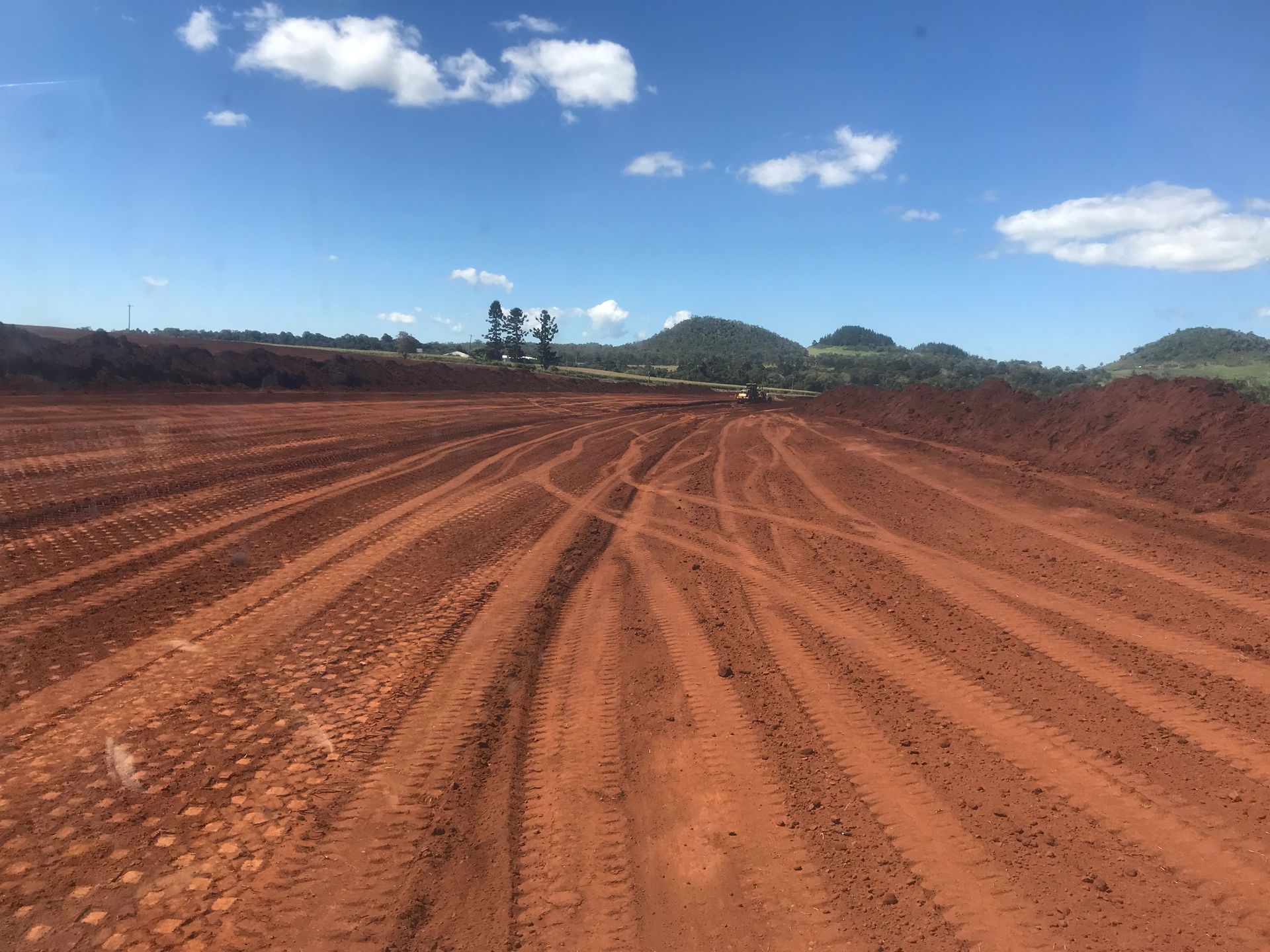 A Yellow Bulldozer Is Moving Dirt in A Quarry — Watto's Earthmoving & Machinery Hire in Atherton, QLD