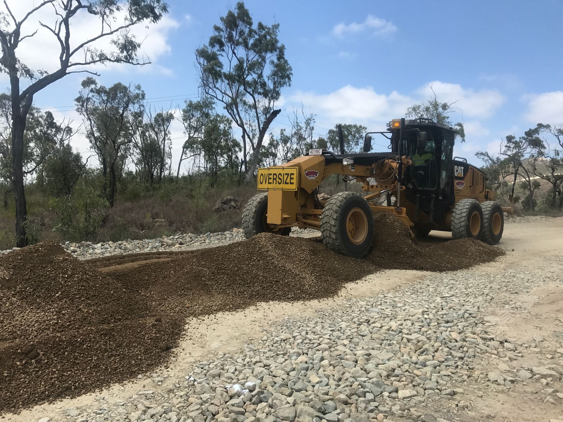 A Yellow Bulldozer Is Loading Coal Into a Truck — Watto's Earthmoving & Machinery Hire in Atherton, QLD