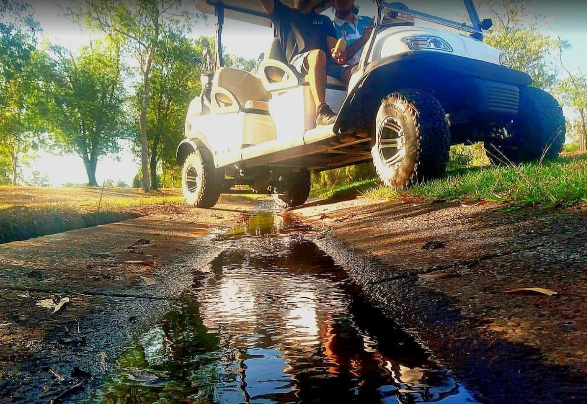 A Golf Cart is Driving Down a Muddy Road — Golf Carts Top End in Howard Springs, NT