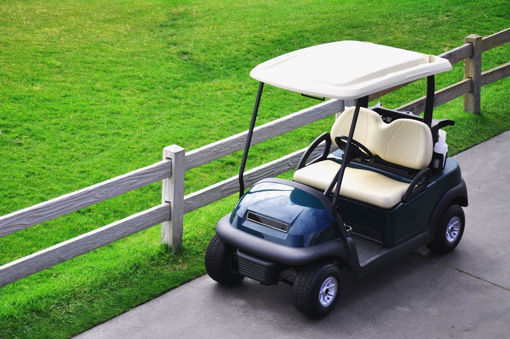 A Golf Cart is Parked on the Side of the Road Next to a Fence — Golf Carts Top End in Humpty Doo, NT