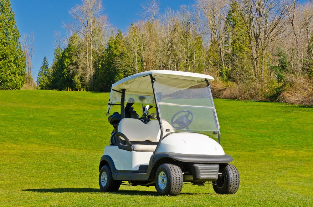 A White Golf Cart is Parked on a Lush Green Golf Course — Golf Carts Top End in Berrimah, NT 