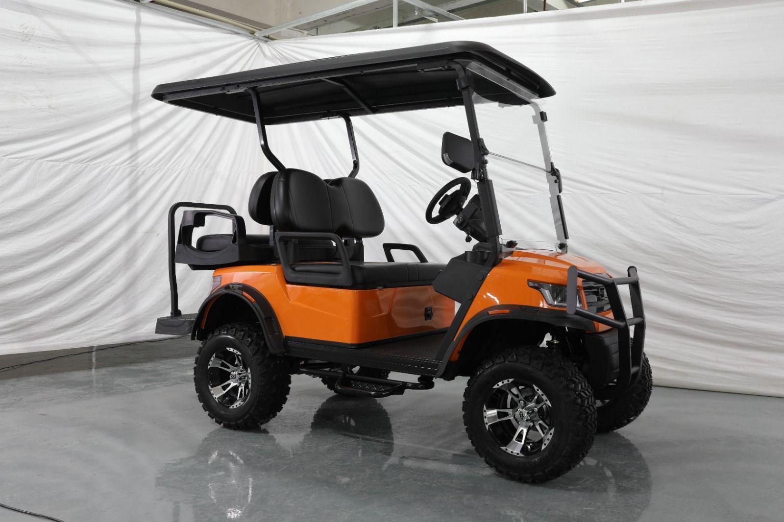 An Orange Golf Cart With a Black Roof is Parked in a Garage — Golf Carts Top End in Winnellie, NT
