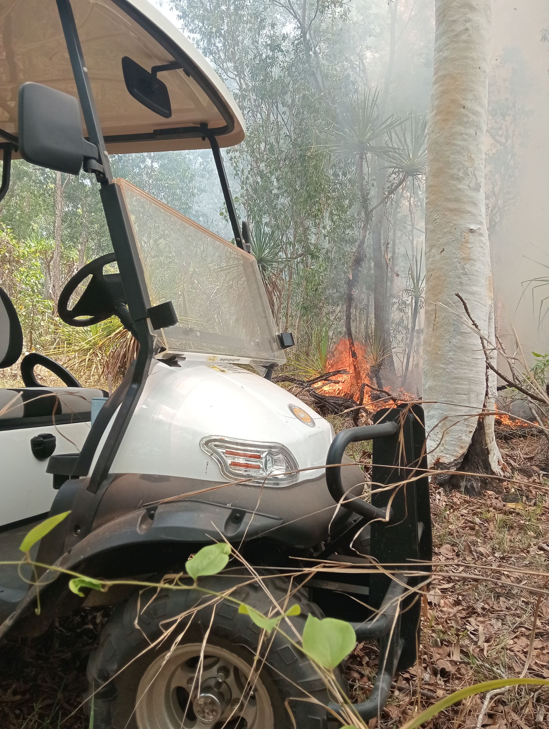 A White Golf Cart is Parked in a Garage Next to a Forklift — Golf Carts Top End in Palmerston, NT
