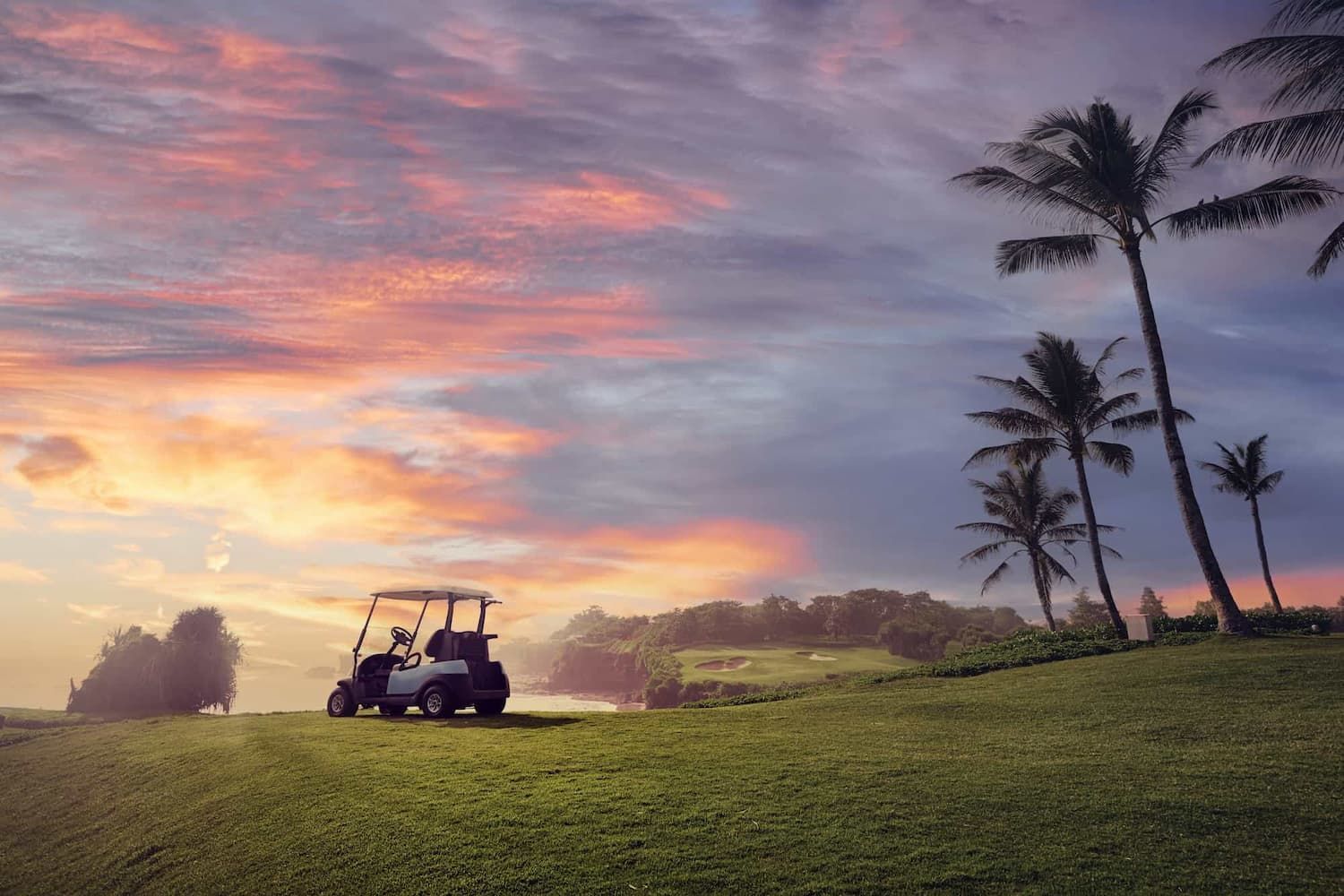 A Golf Cart is Parked on a Golf Course at Sunset — Golf Carts Top End in Casuarina, NT
