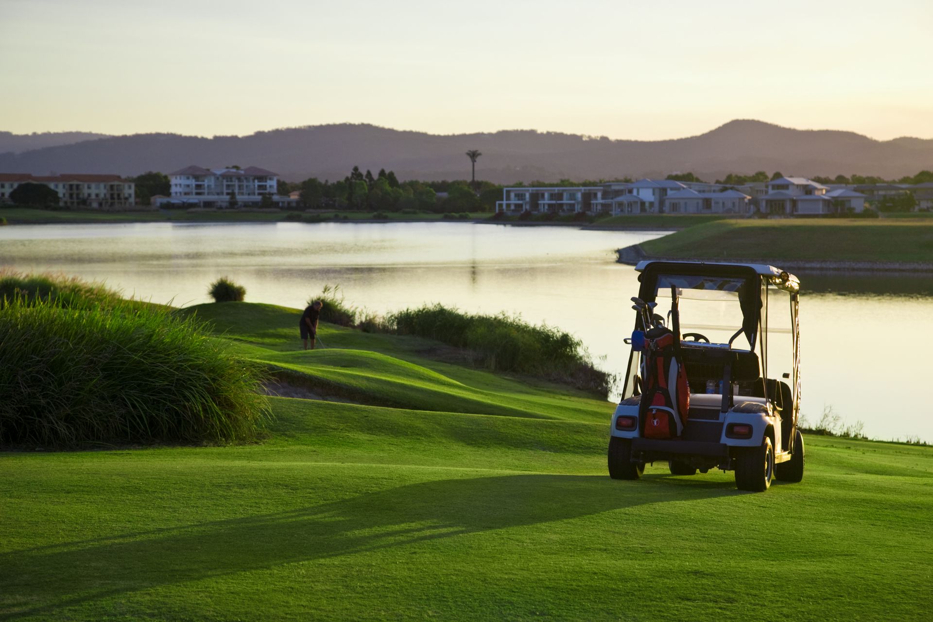 A Golf Cart is Parked on a Golf Course Next to a Lake — Golf Carts Top End in Berrimah, NT