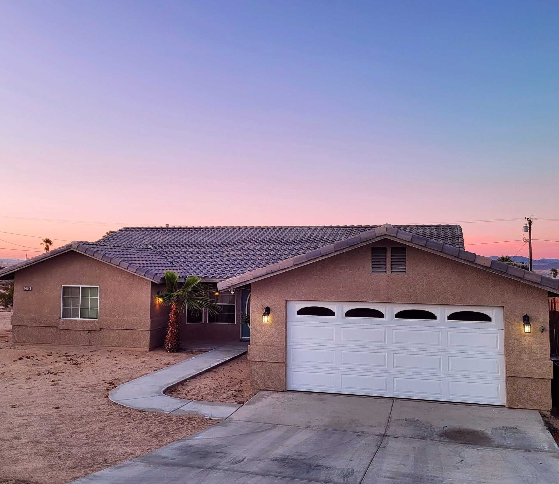 House with white garage door and stucco exterior of house