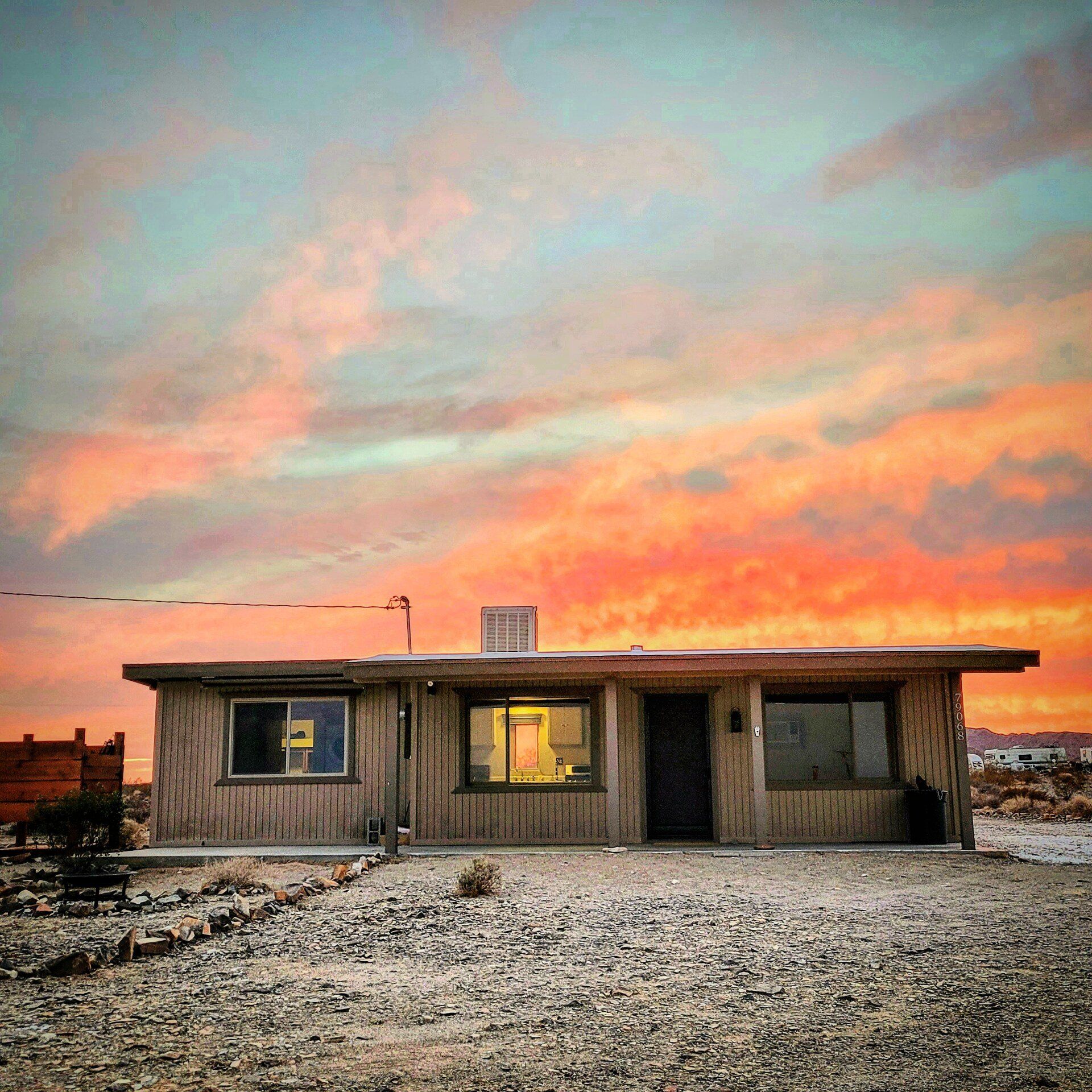 Brown single level home with sunset in background