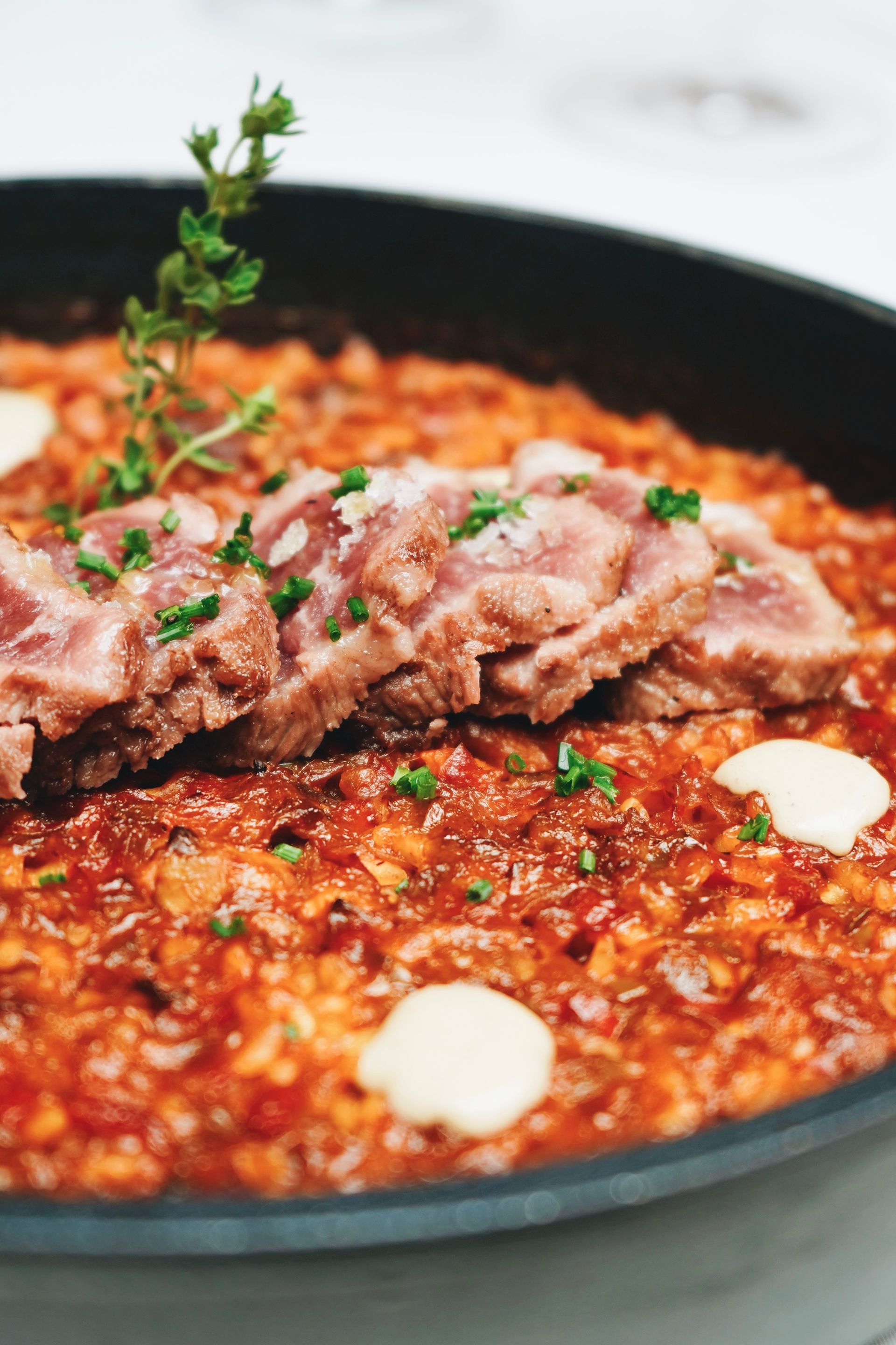 Un primer plano de un plato de comida con carne y salsa sobre una mesa.