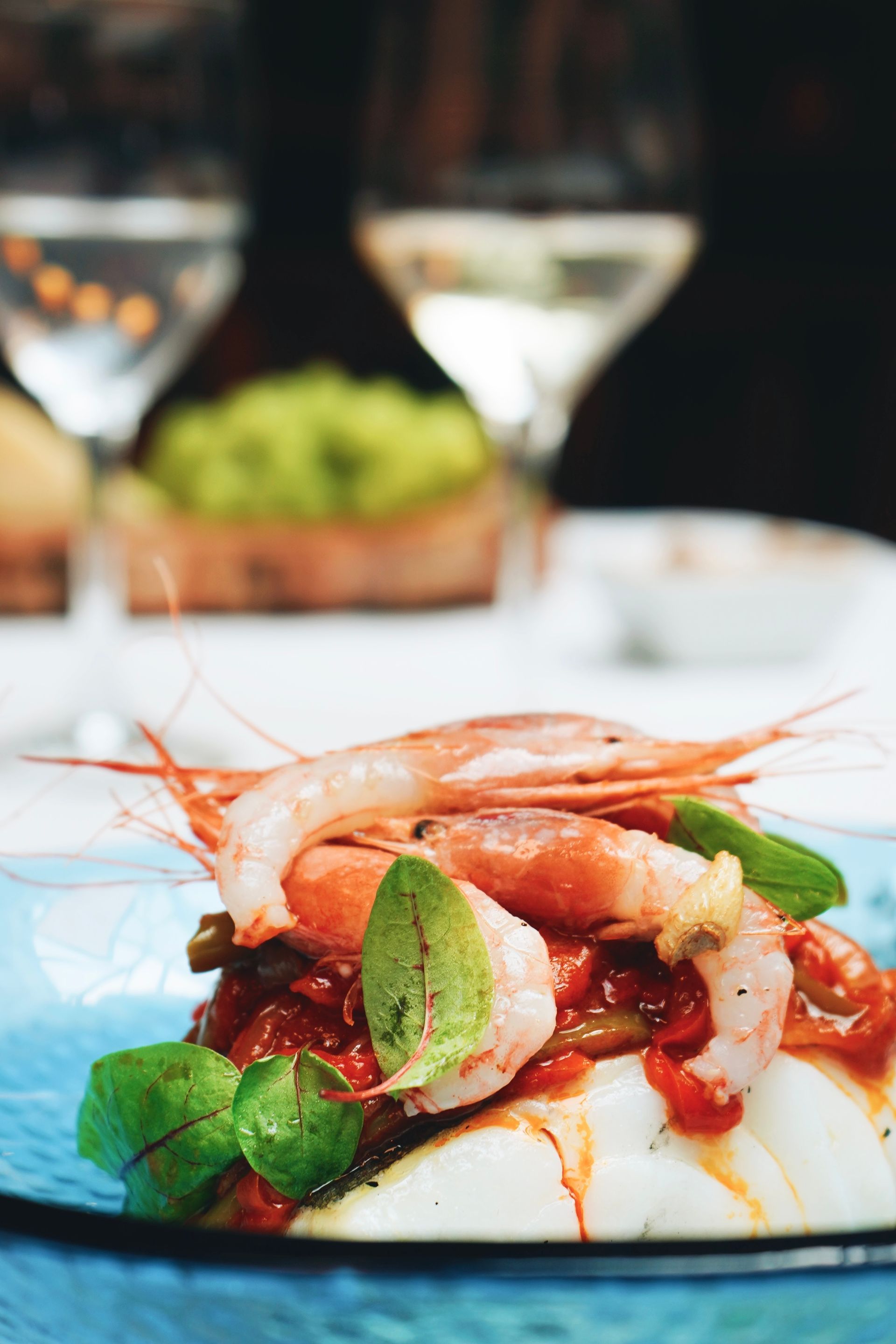 Un plato de comida con camarones y verduras sobre una mesa
