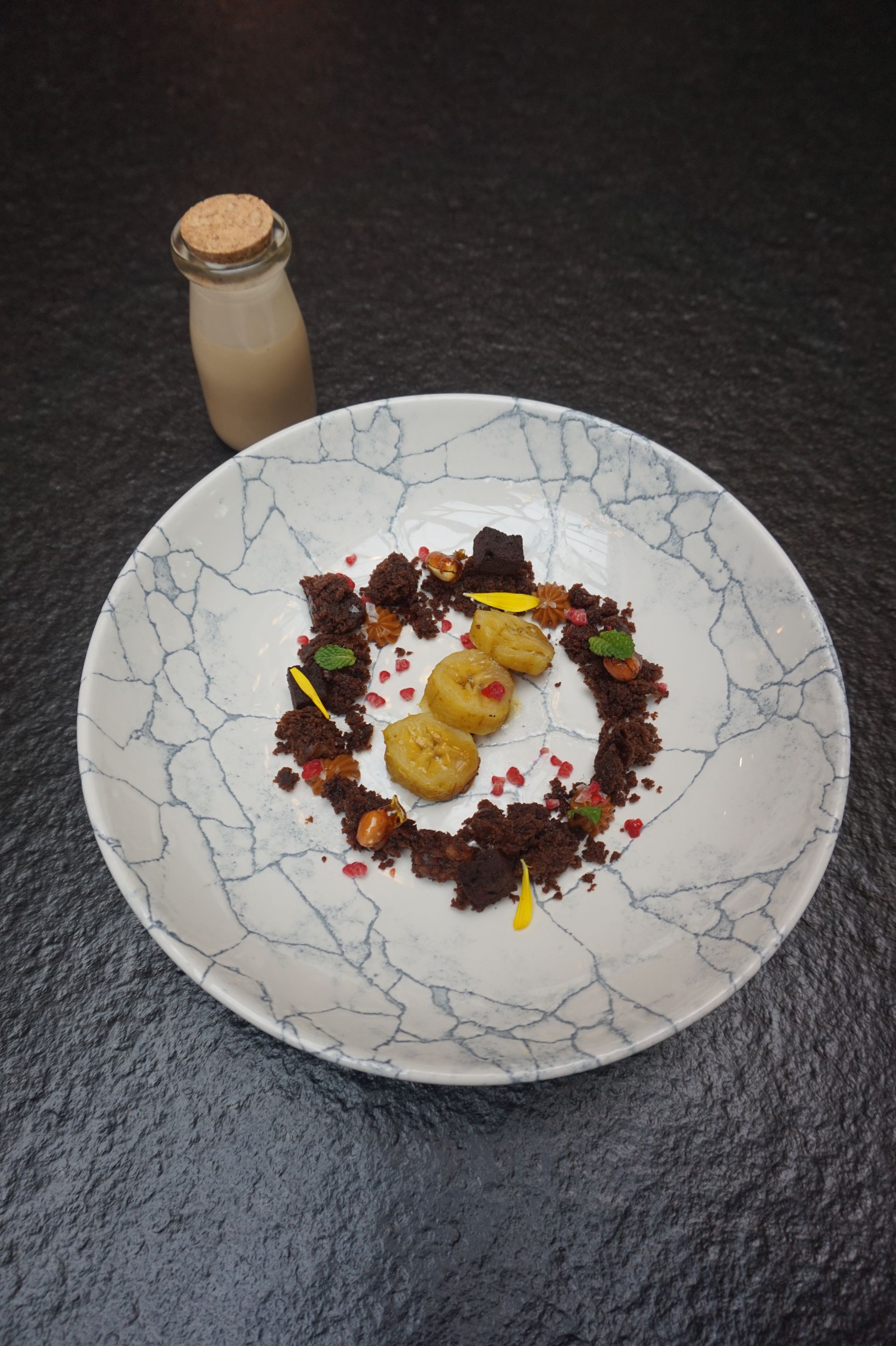 Un plato de comida con una botella de leche al fondo.