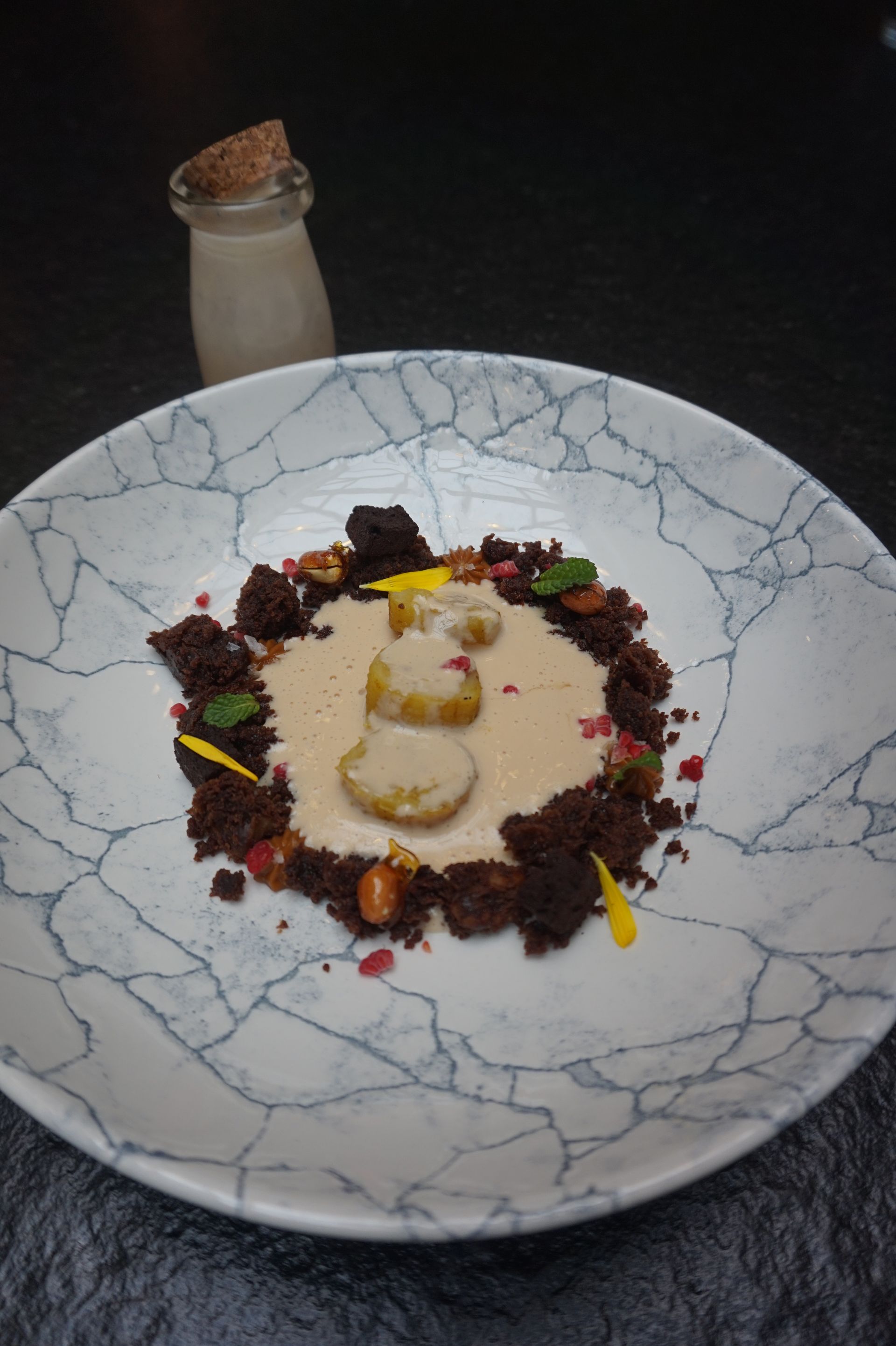 Un plato de comida con una botella de leche al fondo.