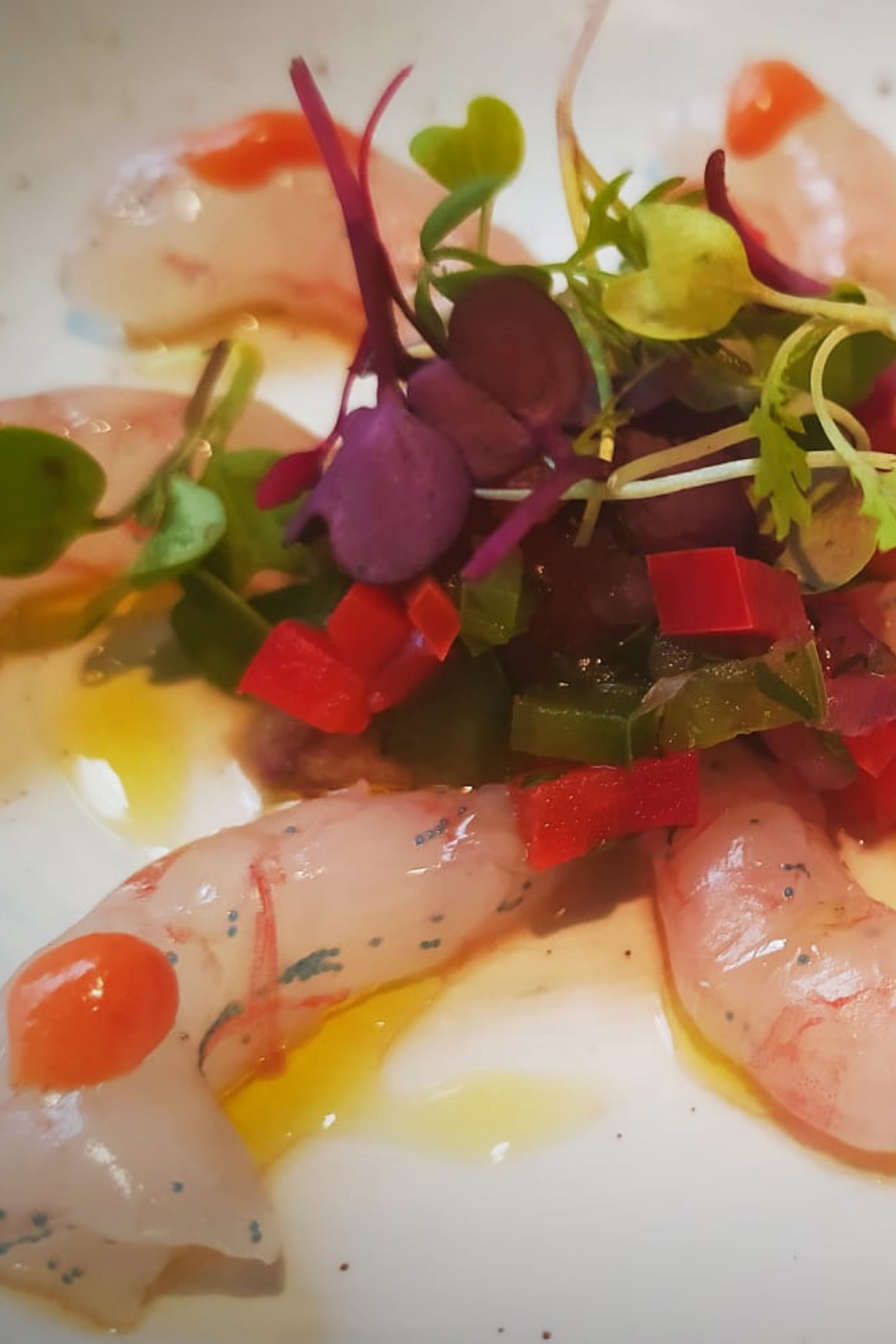 Un primer plano de un plato de comida con camarones y verduras.