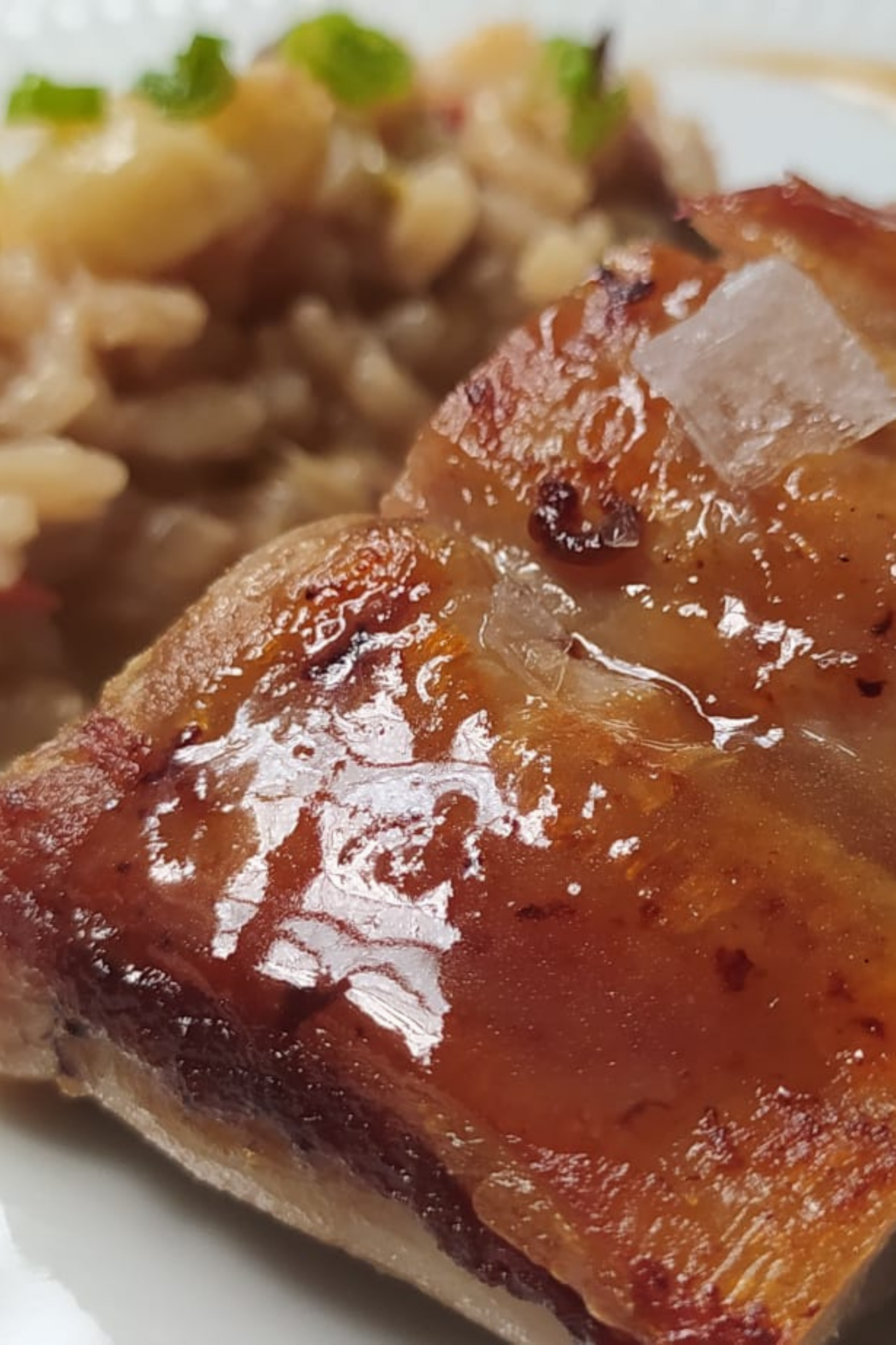 Un primer plano de un trozo de carne en un plato con arroz