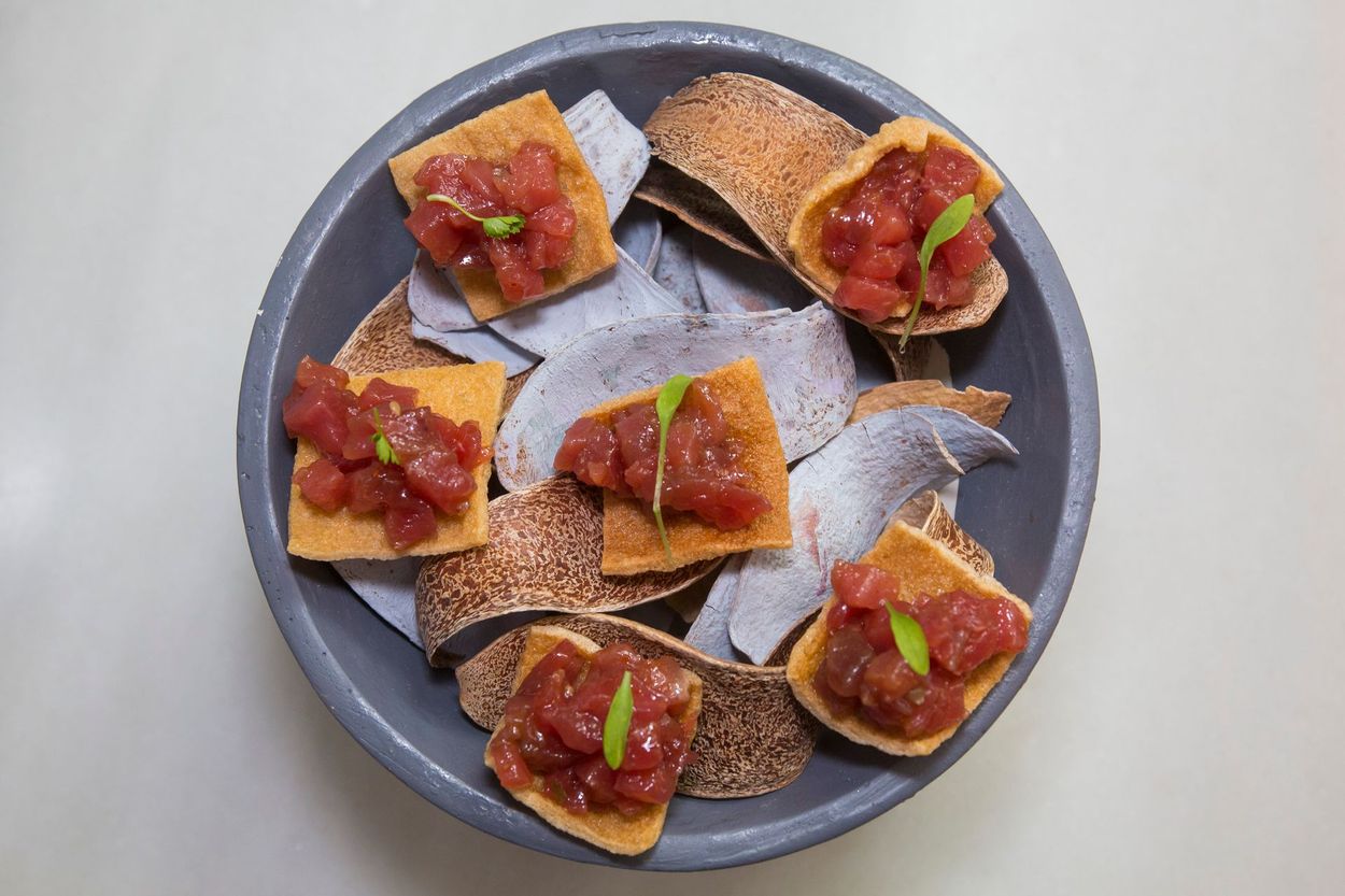 Un plato de comida con salsa de tomate y galletas saladas sobre una mesa.