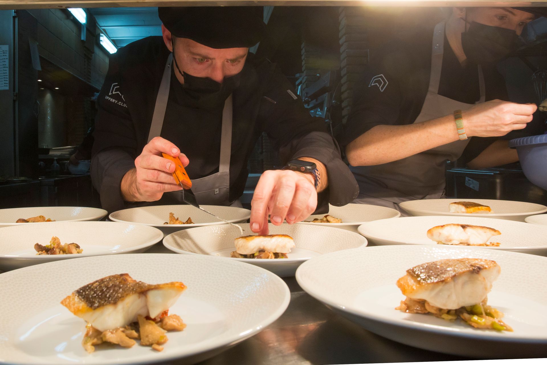 Un chef está preparando un plato de comida en la cocina.