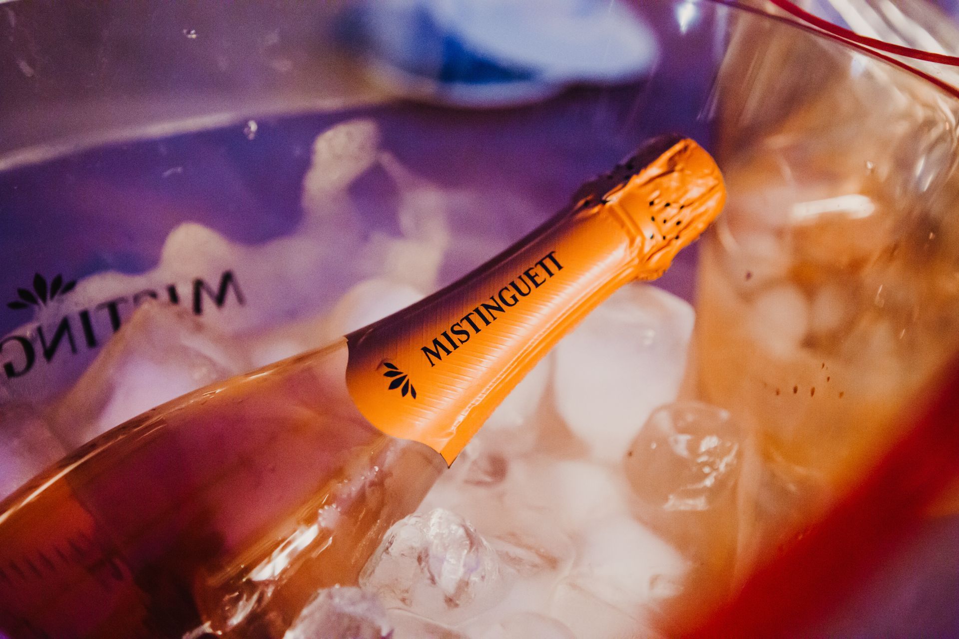 Hay una botella de champán mistinguetti en un cubo de hielo.