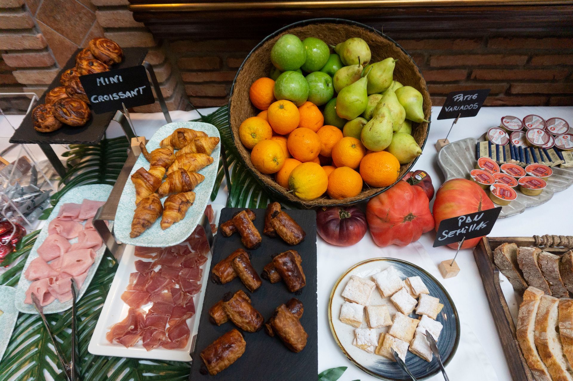 Una mesa cubierta con platos de comida y una cesta de frutas.