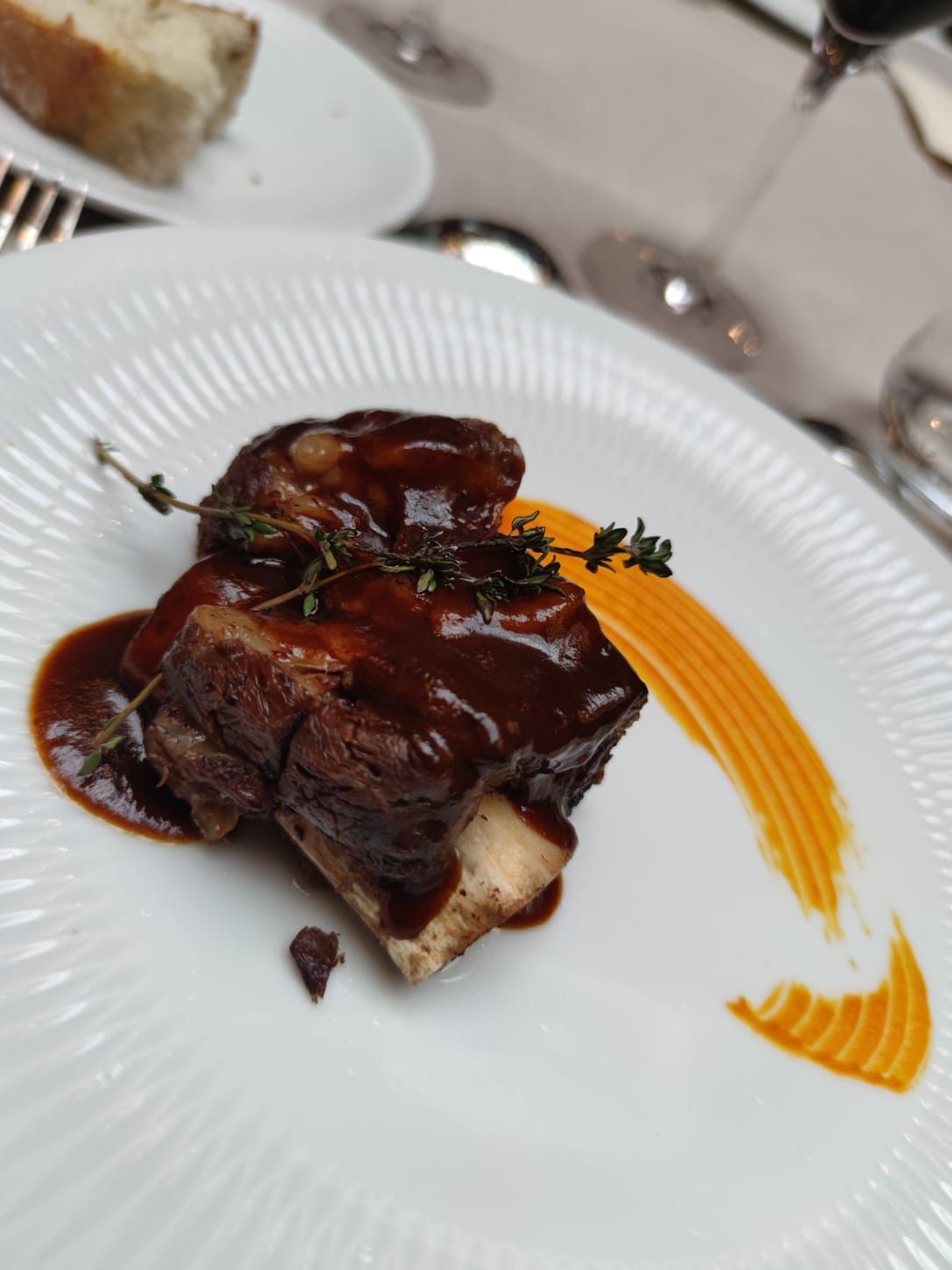 Un plato blanco cubierto con un trozo de carne y salsa.