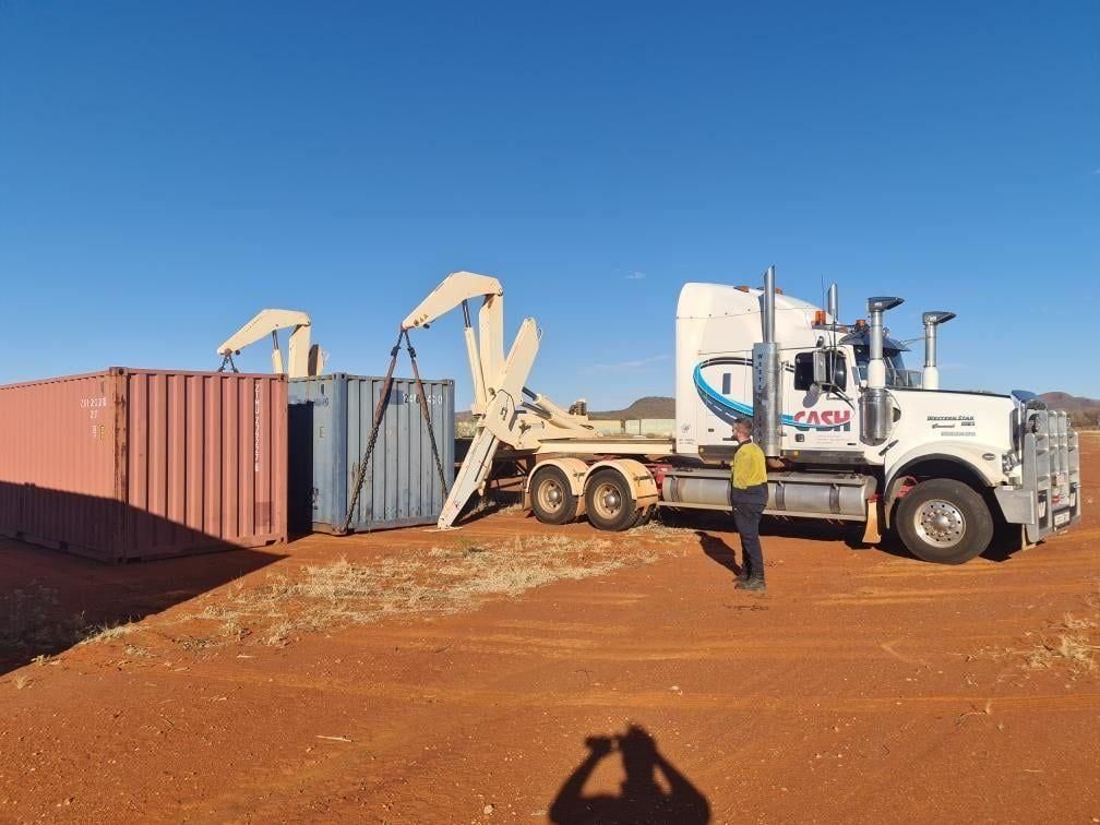 A Man Is Standing in Front of A Truck that Is Carrying a Container — Spinifex Container Solutions In Ciccone, NT