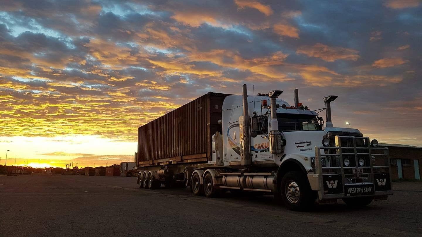 A Semi Truck Is Parked in A Parking Lot at Sunset — Spinifex Container Solutions In Ciccone, NT