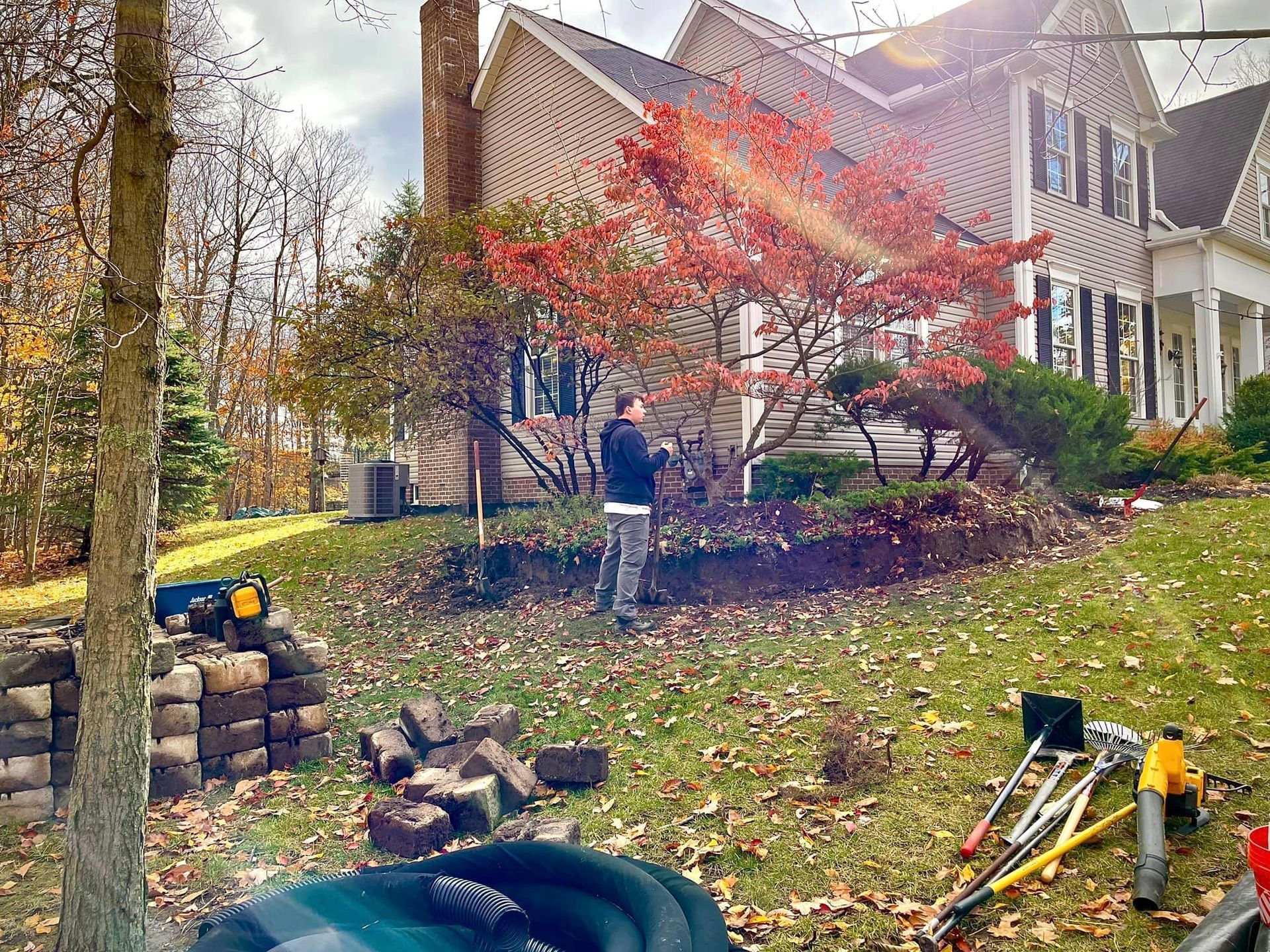 A man is standing in a yard in front of a house.