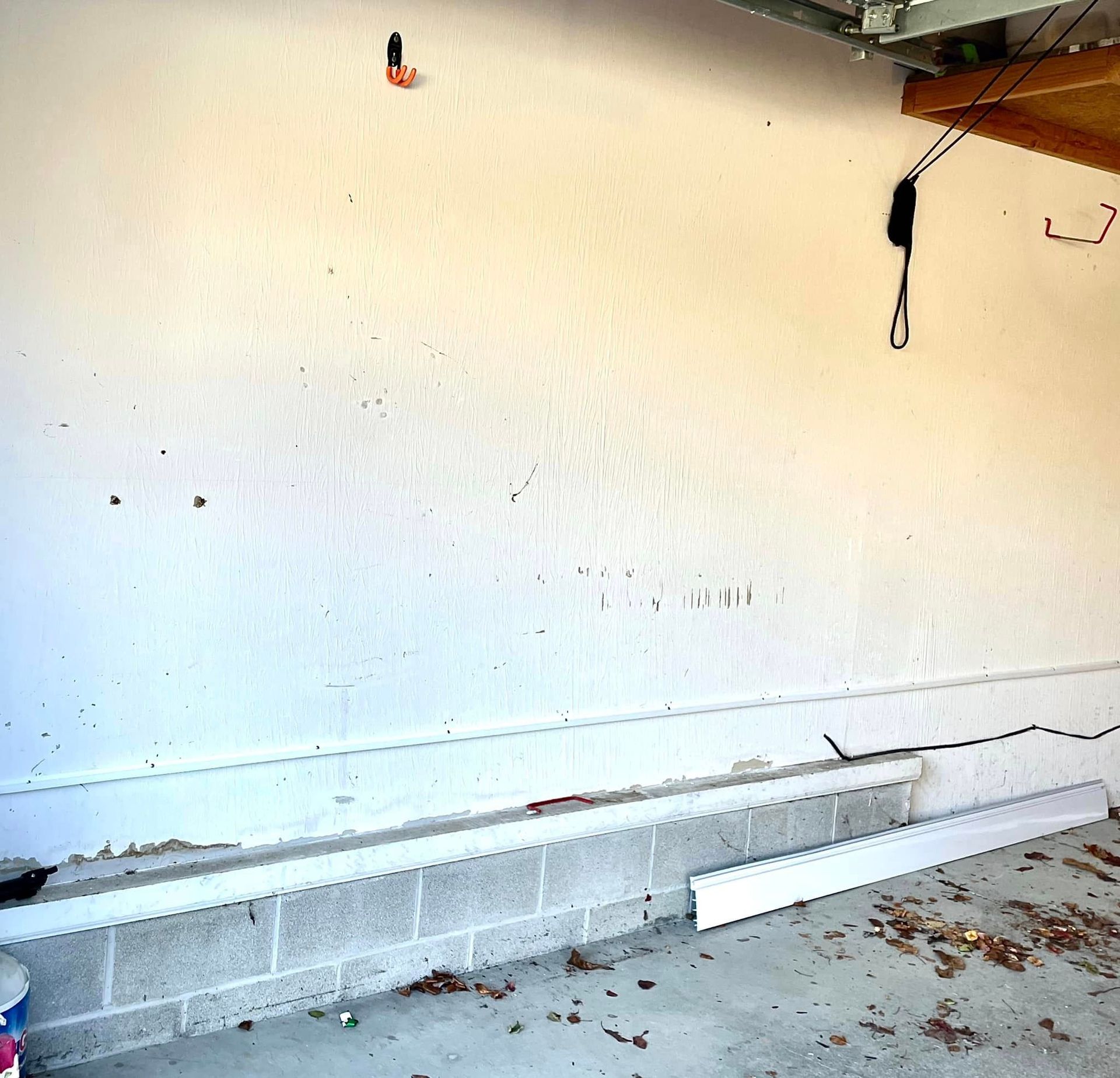 An empty garage with a white wall and a brick wall.