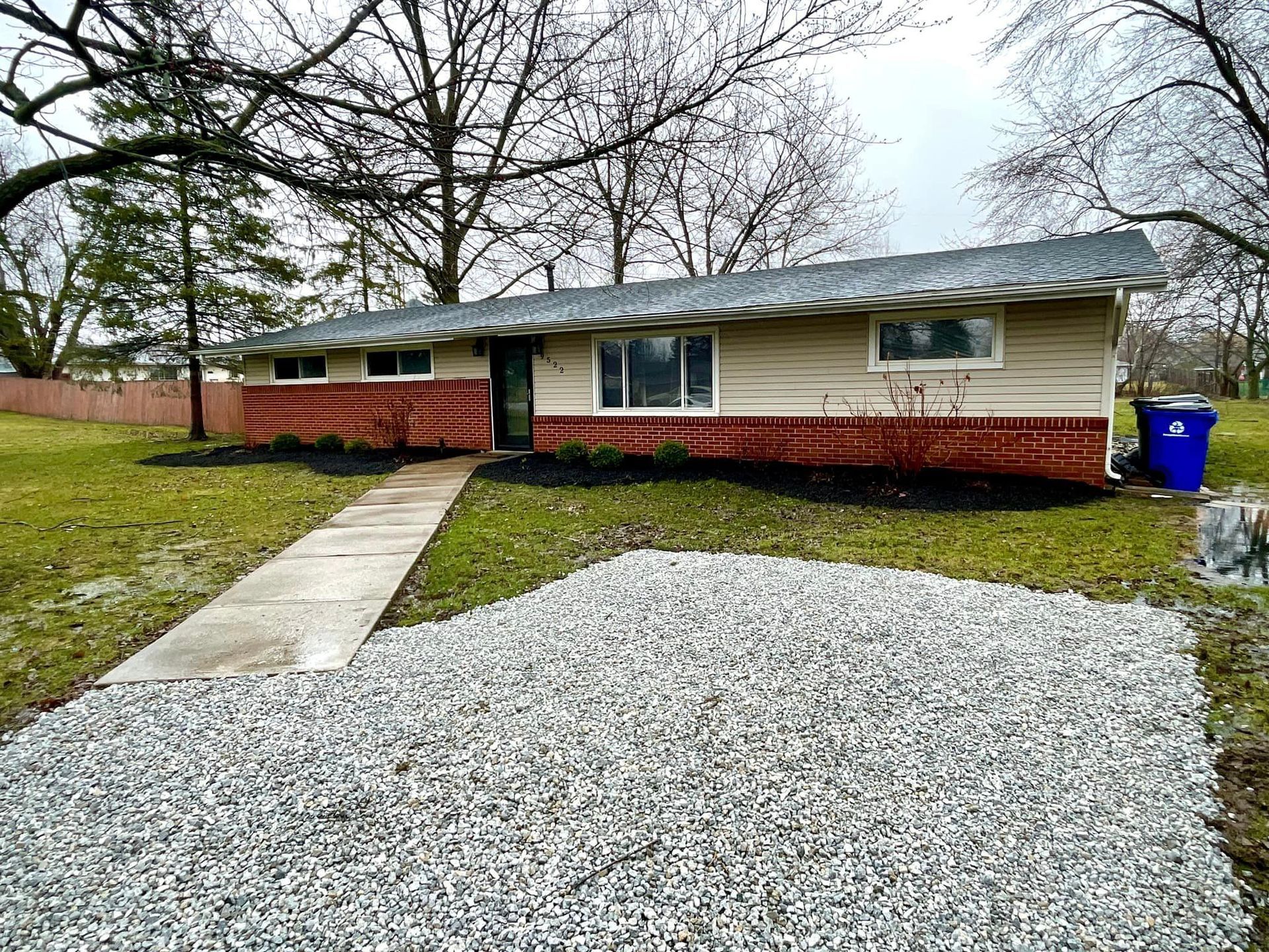 A house with a gravel driveway in front of it.
