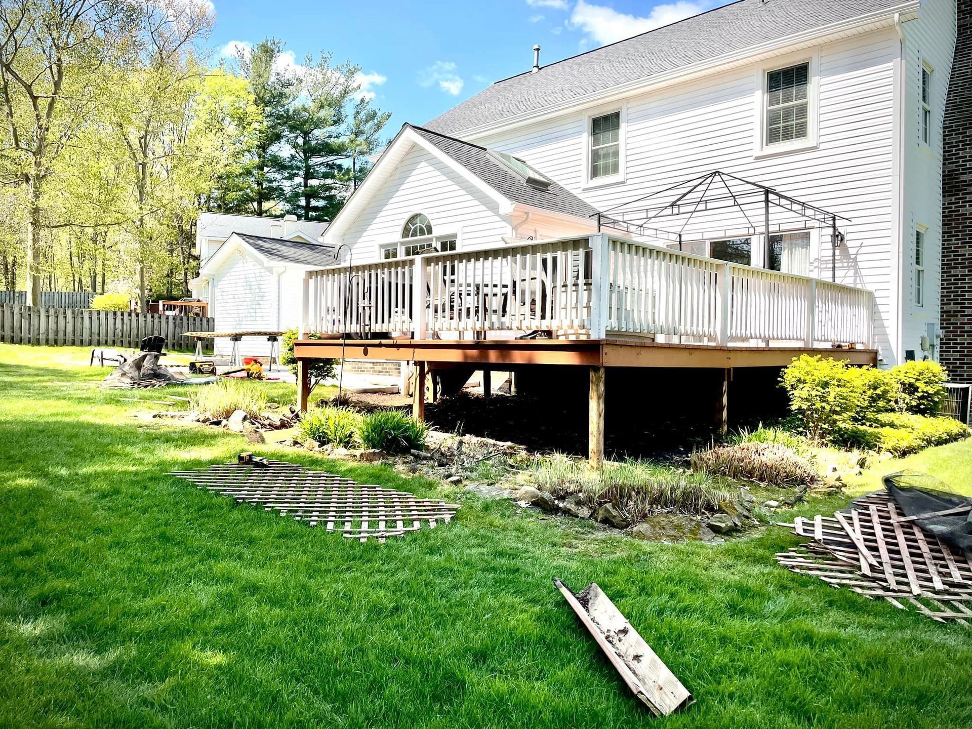 A large white house with a large deck in the backyard.