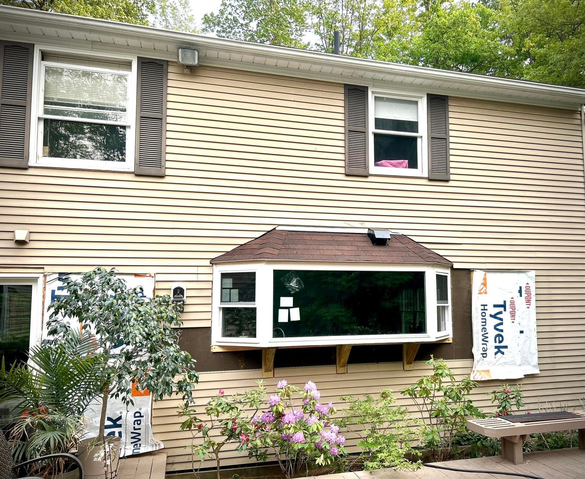 A house with a large window and a bench in front of it.
