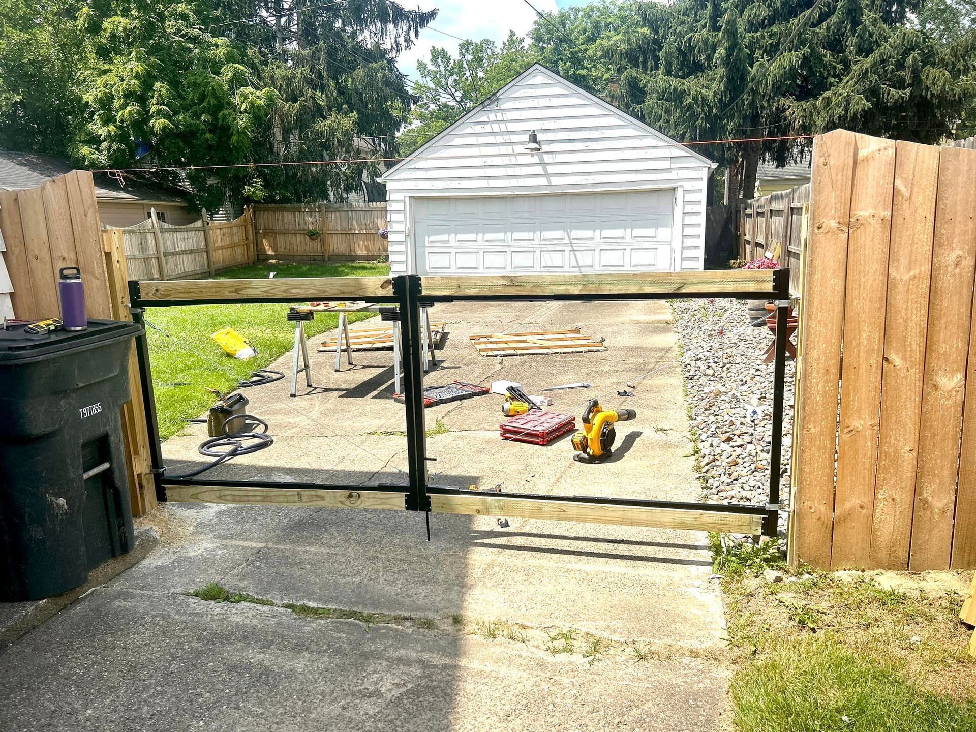 A wooden fence is being built in front of a garage.