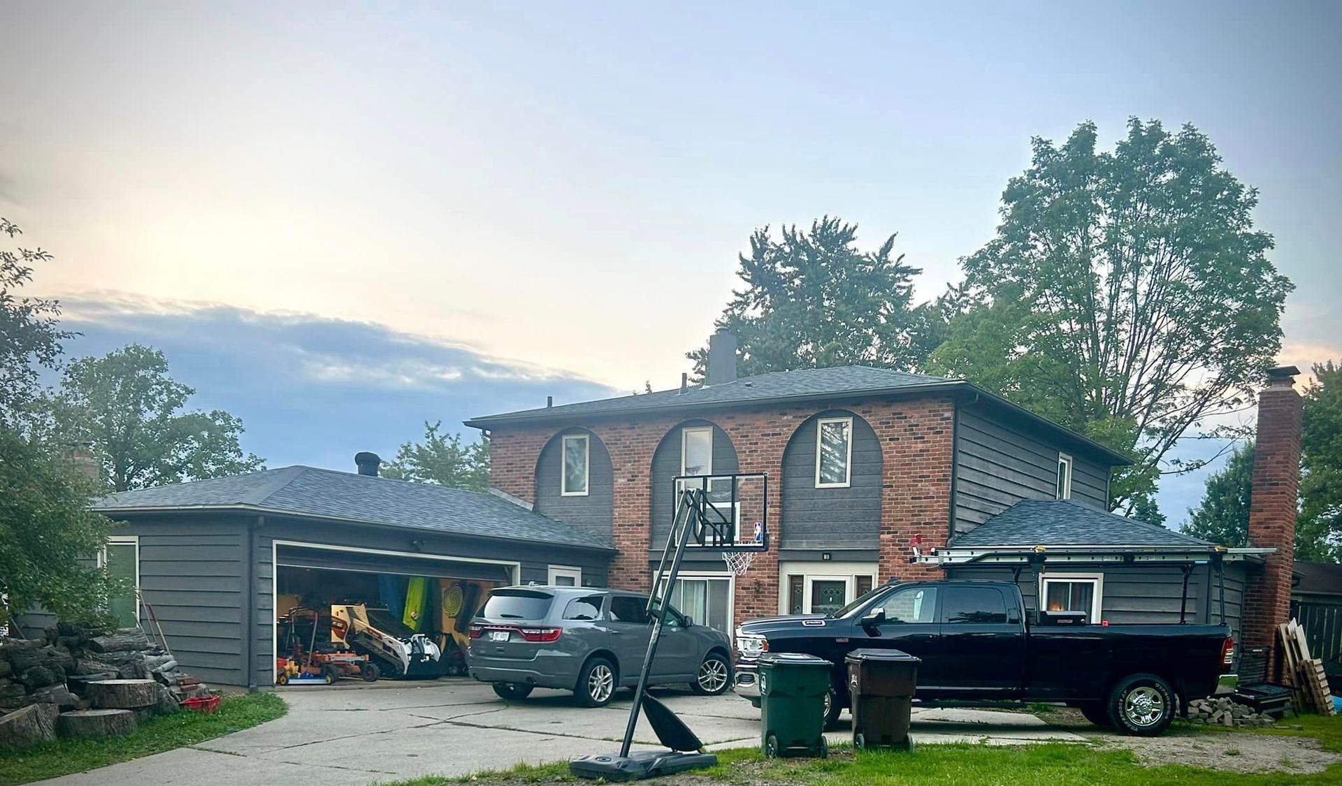 A black truck is parked in front of a large house.