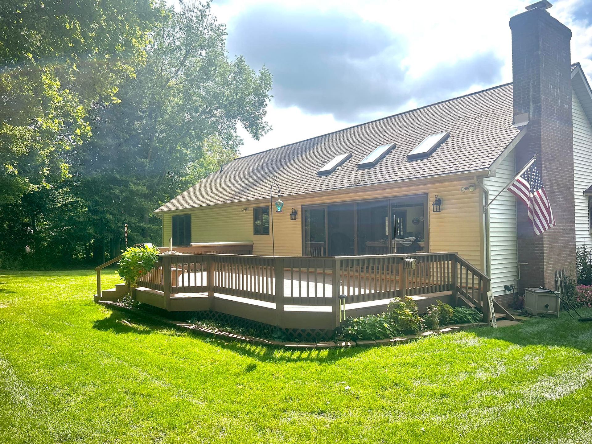 The back of a house with a large deck and an american flag