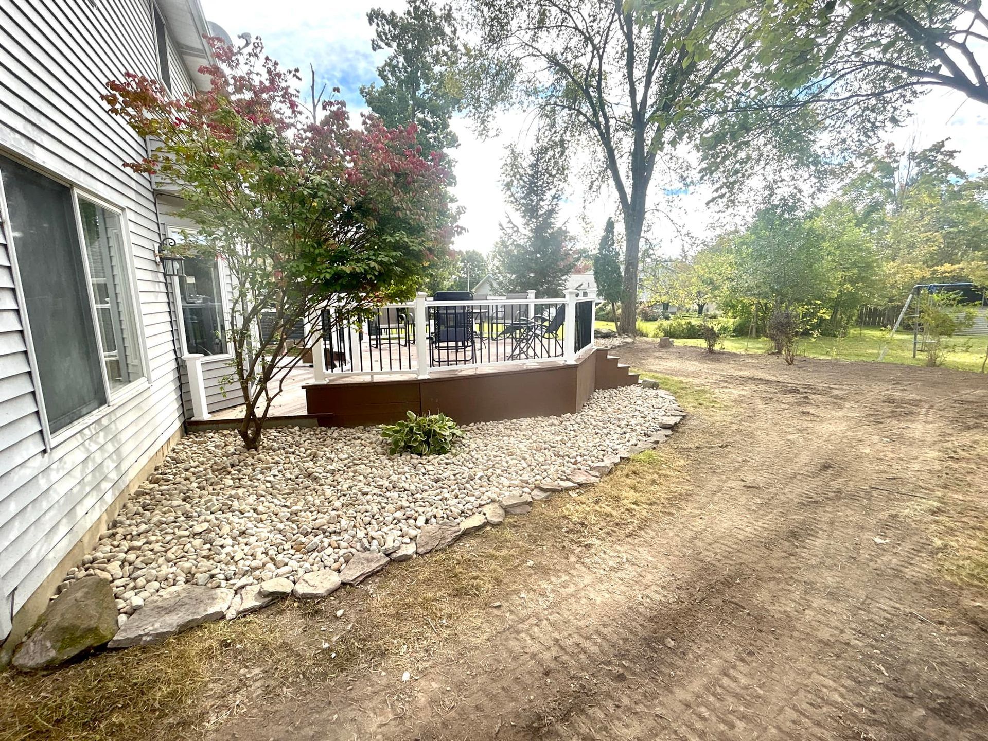 There is a deck in the backyard of a house.