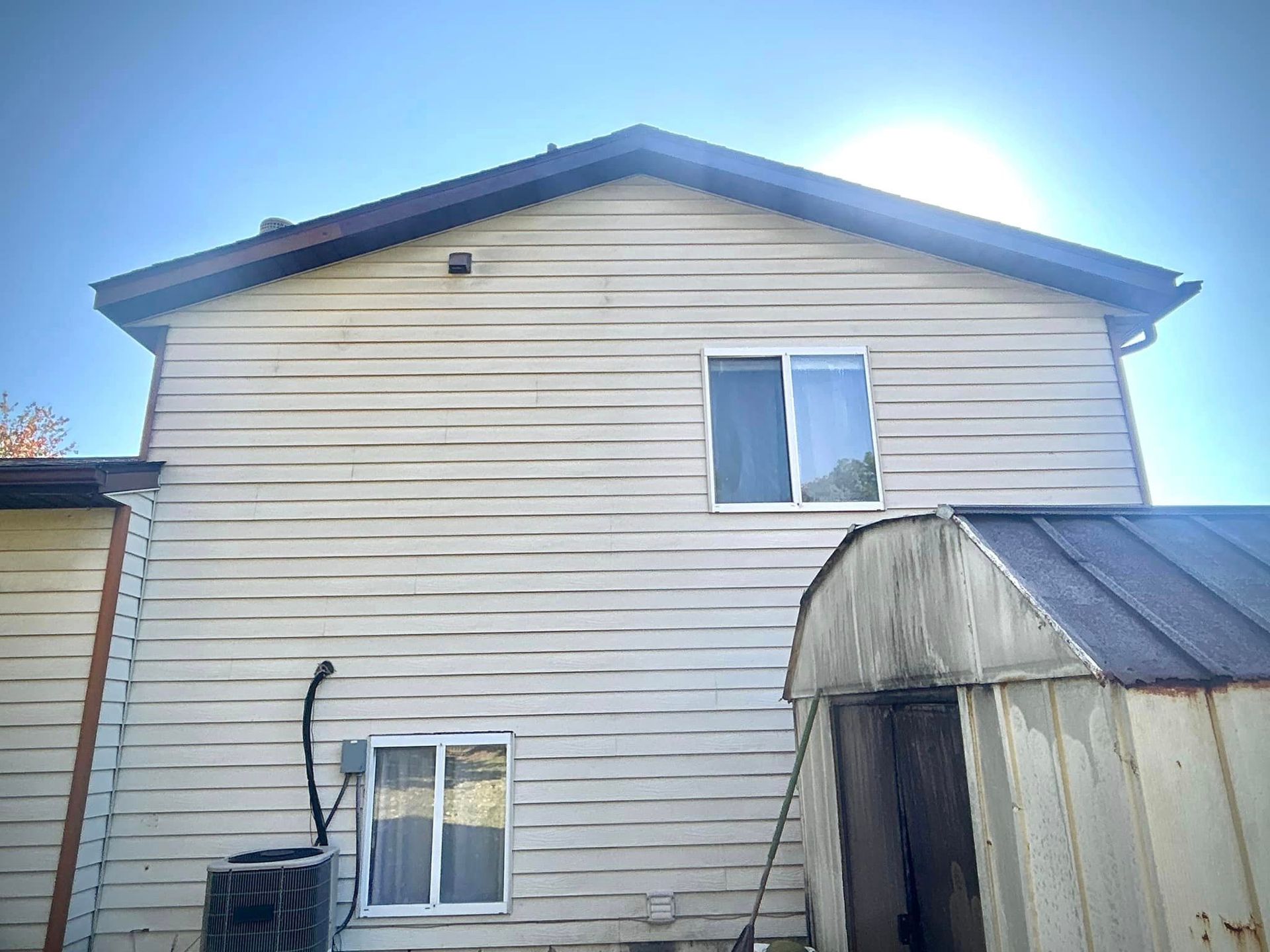 The back of a house with a shed and a window.