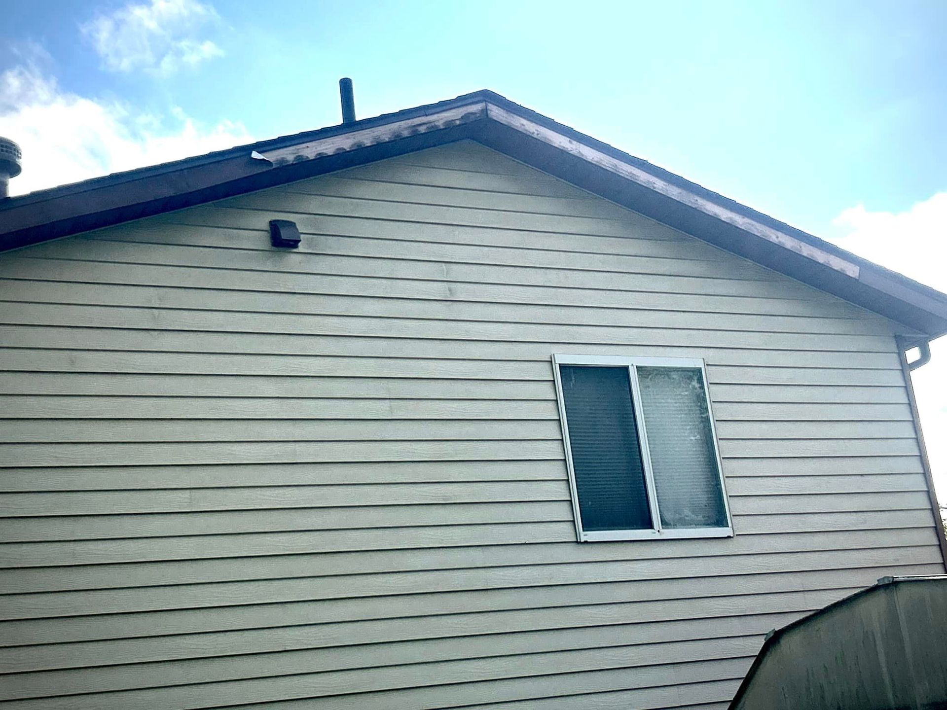 A white house with a window on the side of it.