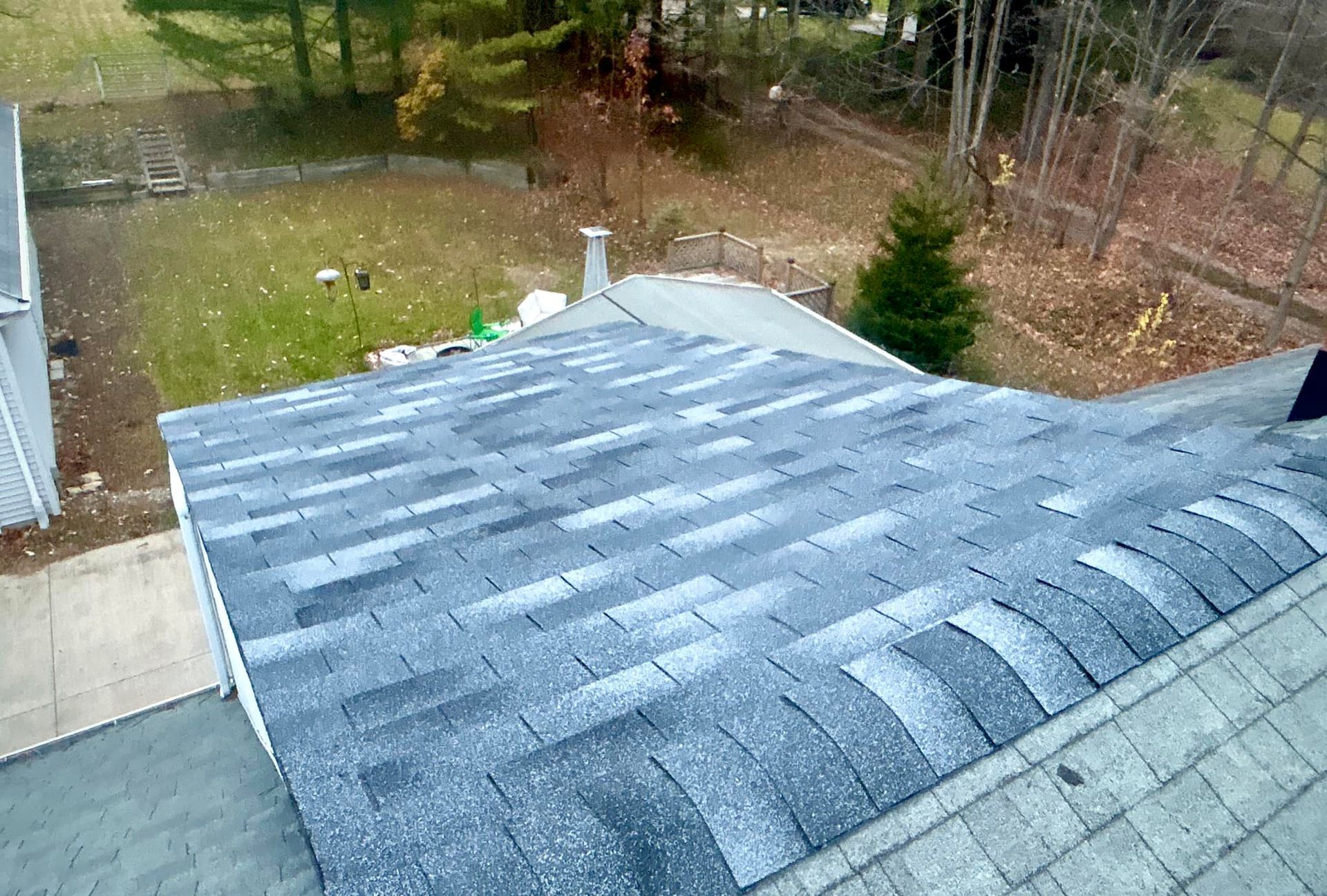 A roof with a lot of shingles on it is being installed on a house.